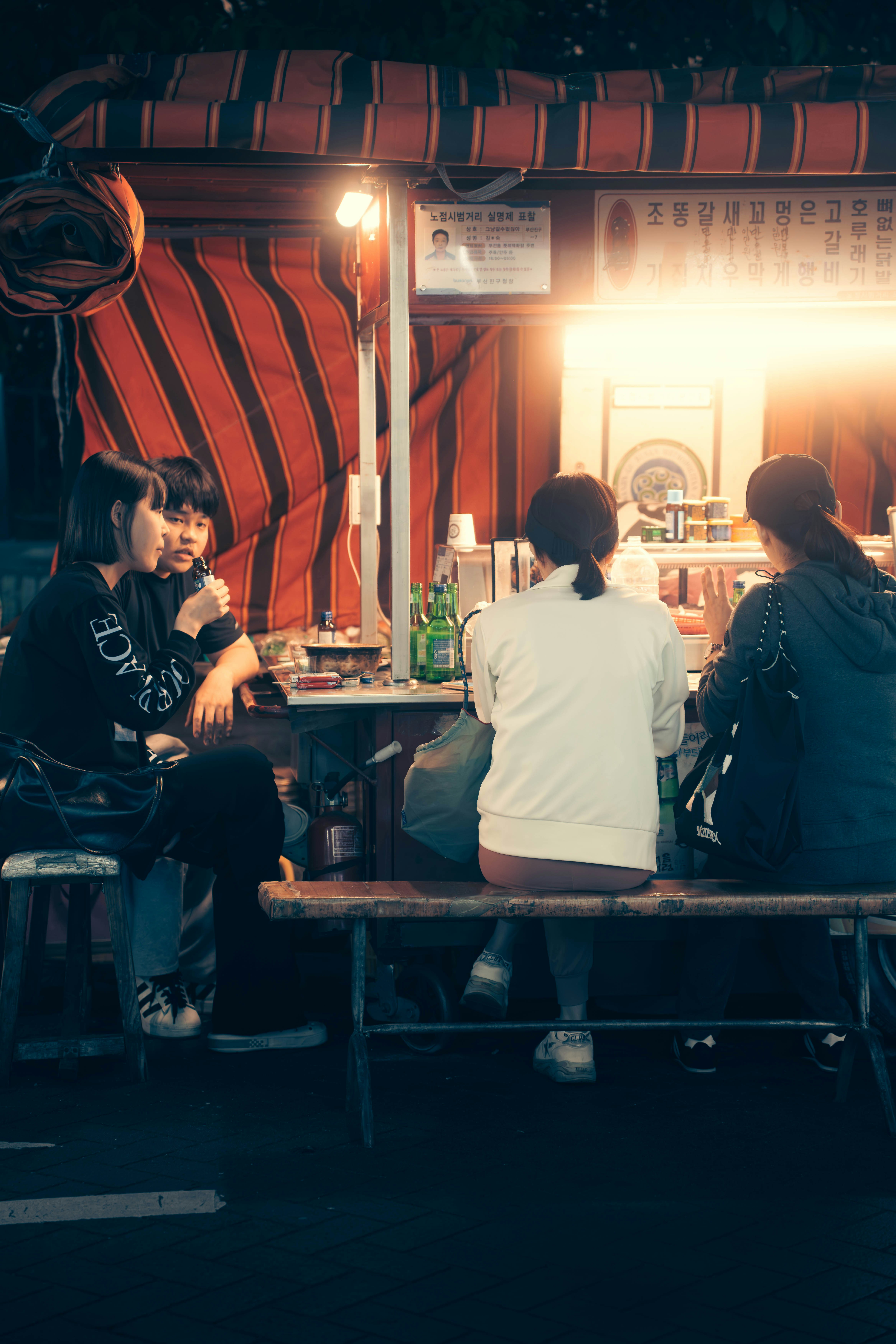 Ambiente cálido de puesto de comida callejera con luces doradas y clientes satisfechos