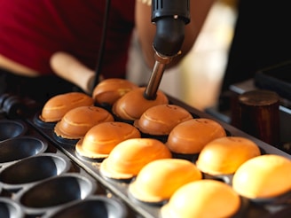 A person making cupcakes on a tray