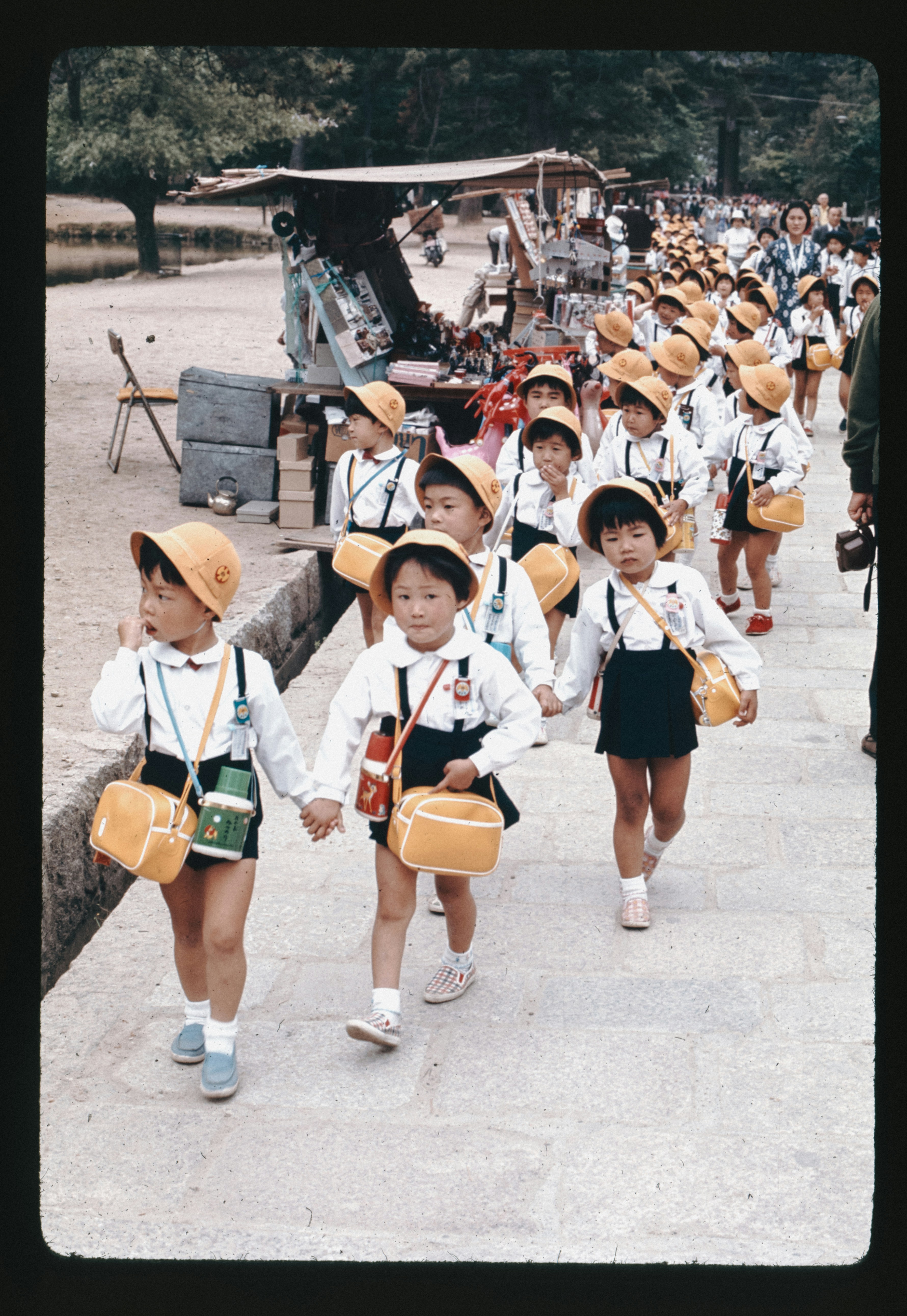 A group of young children walking down a sidewalk