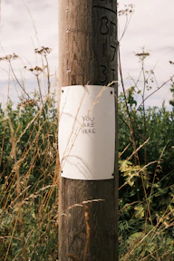 A wooden pole with a sign attached to it