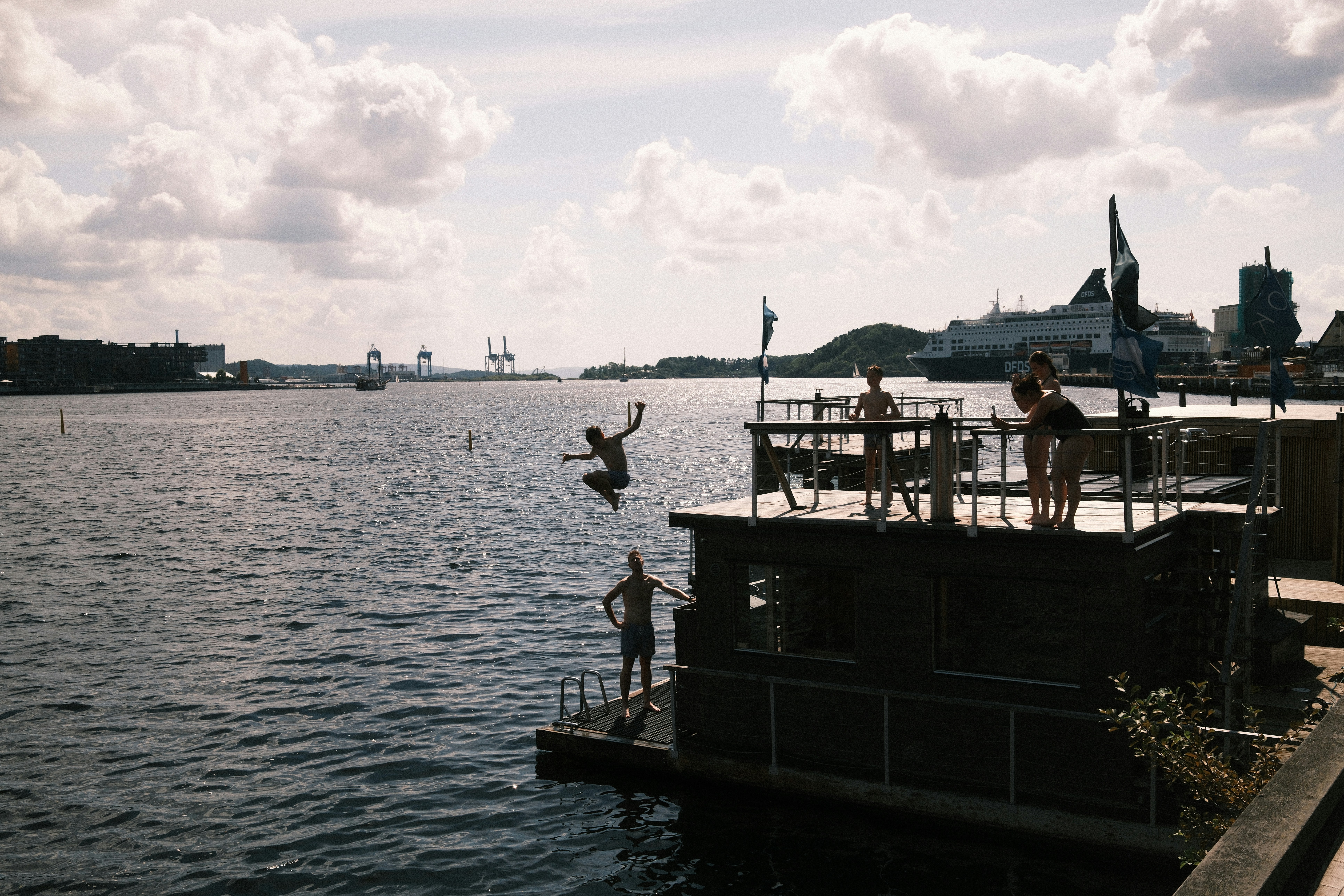 A person jumping off a dock into the water