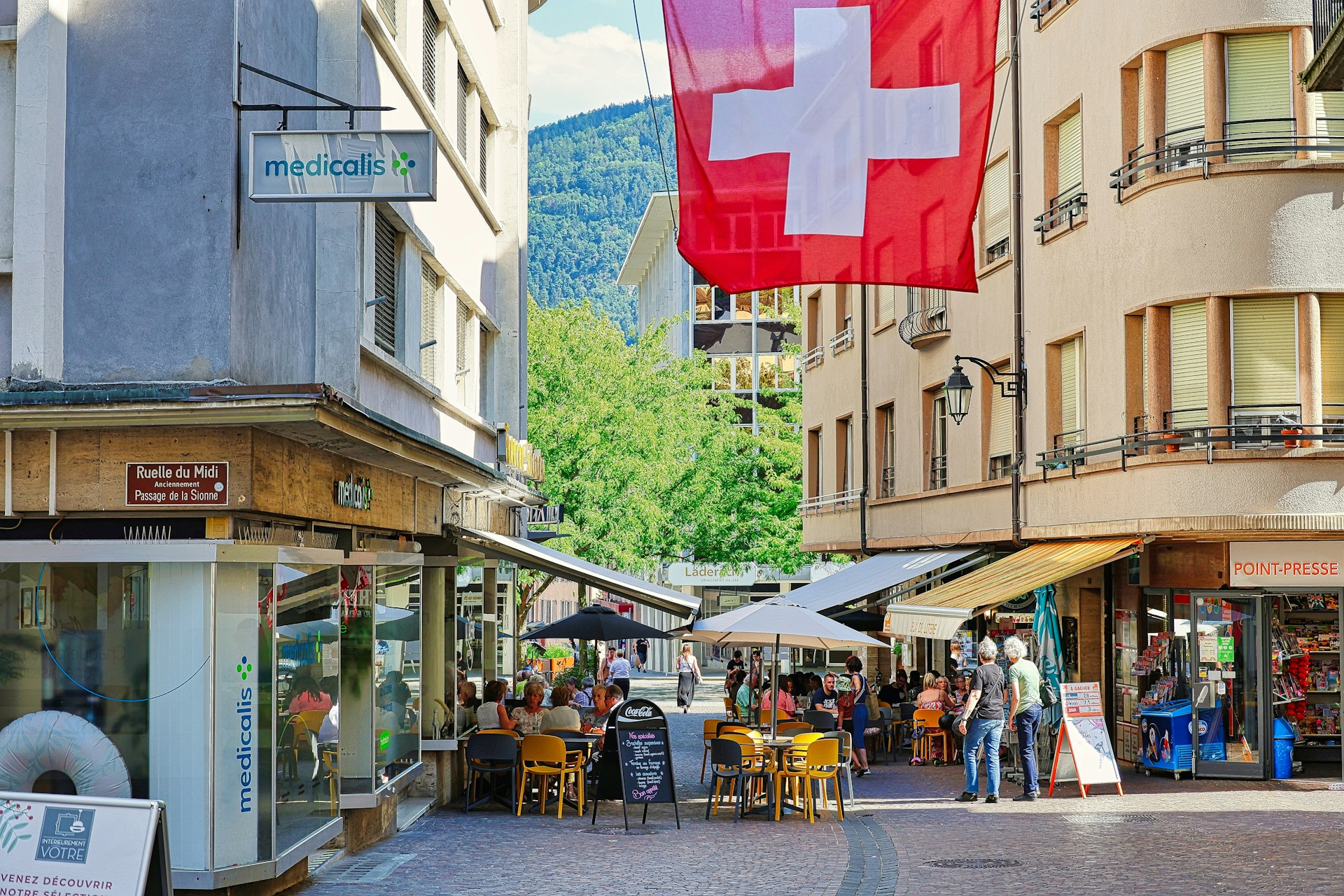 A red and white flag flying over a city street