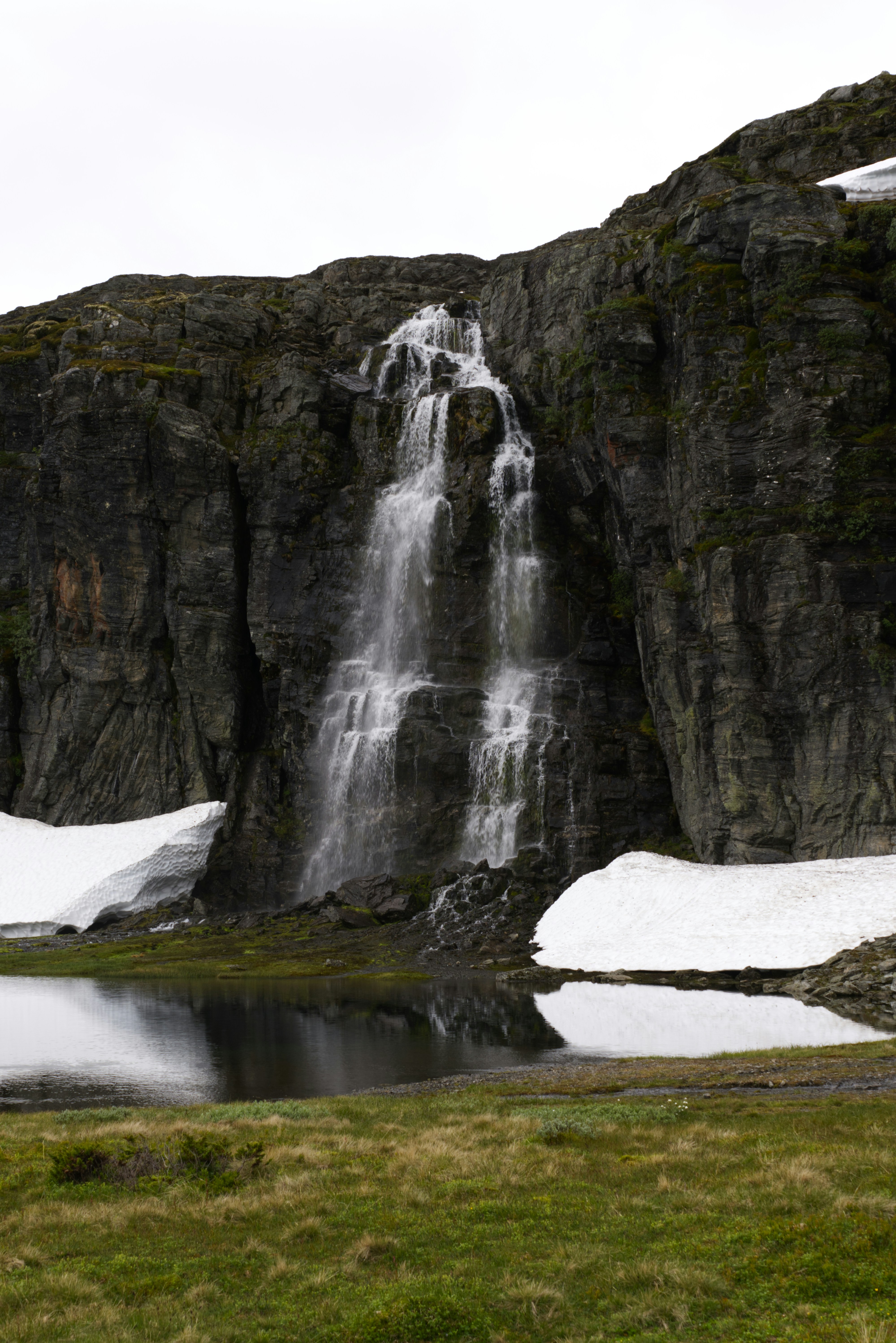 A waterfall in the middle of a snow covered field