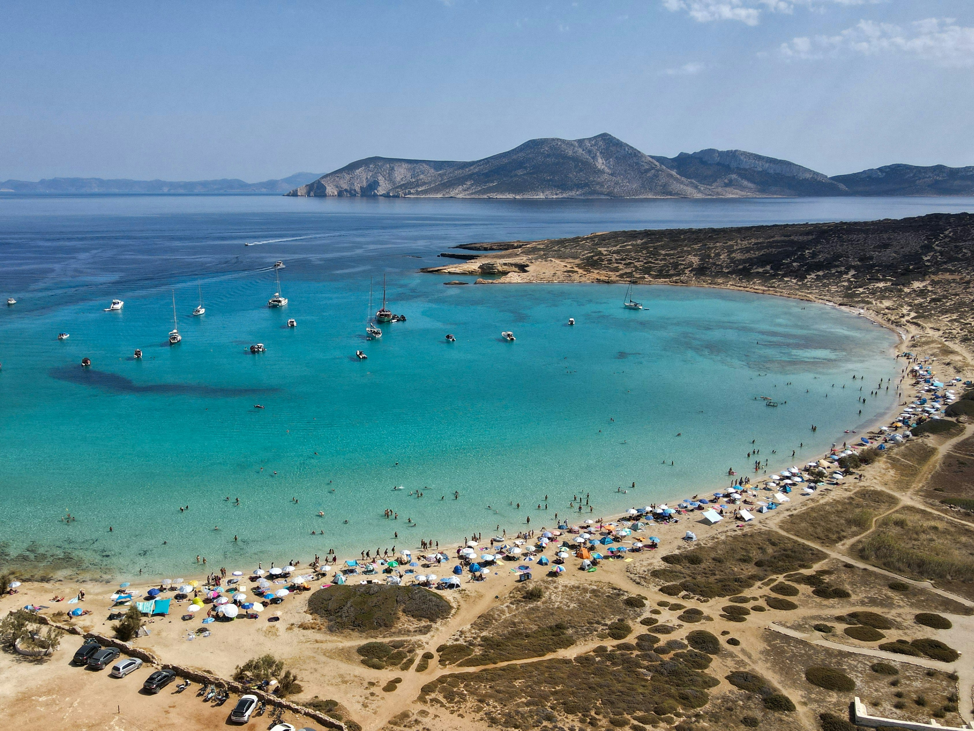 An aerial view of a beach with boats in the water