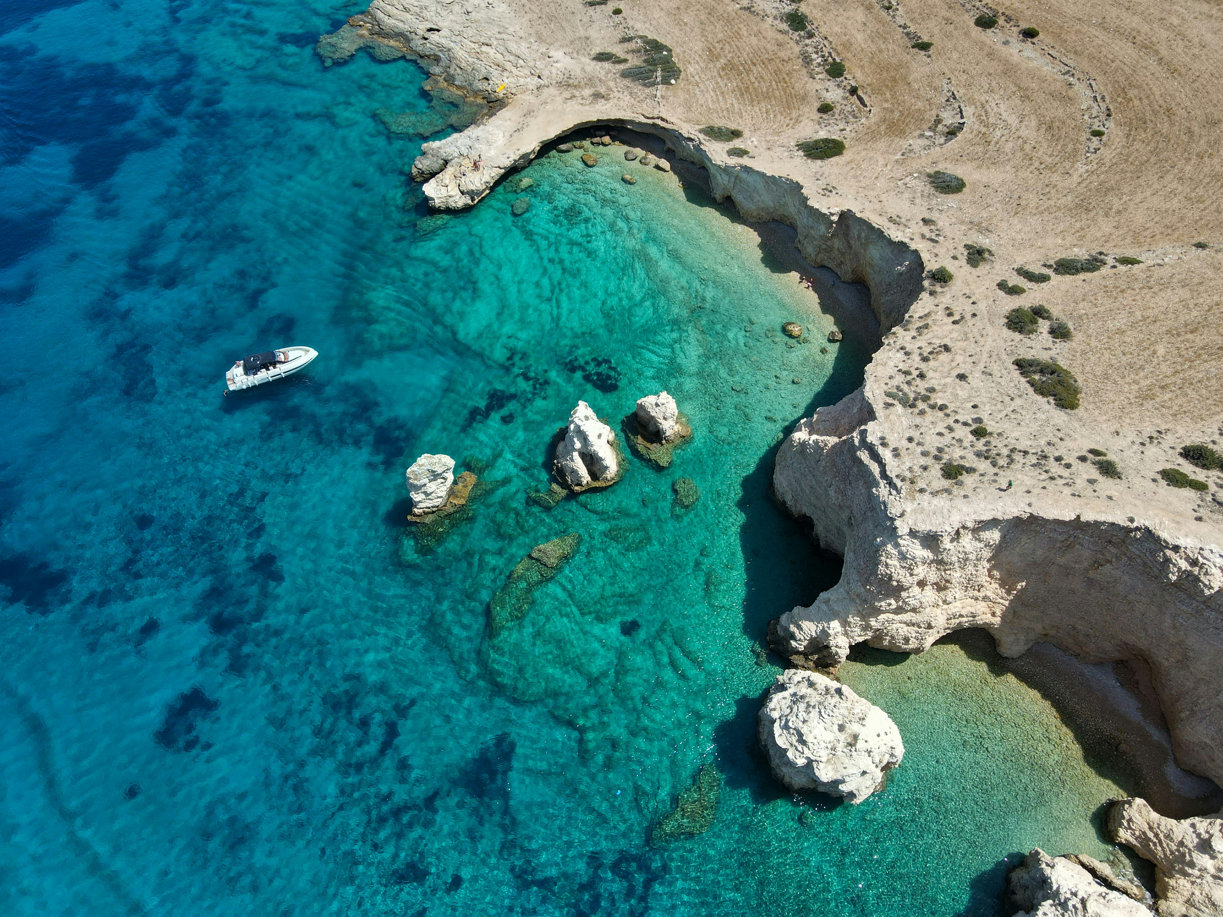 An aerial view of a beach with boats in the water