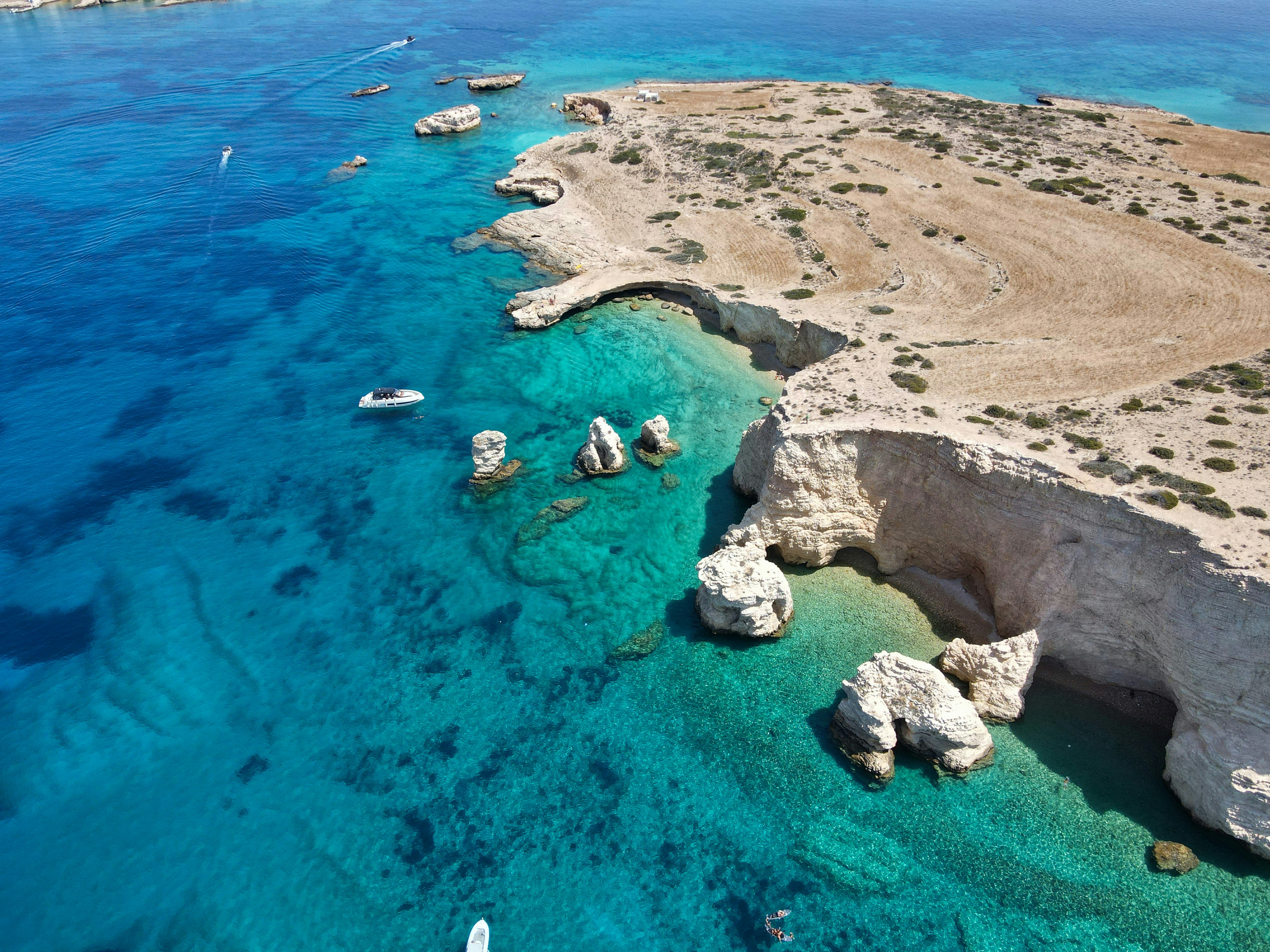 An aerial view of a blue lagoon with boats in it