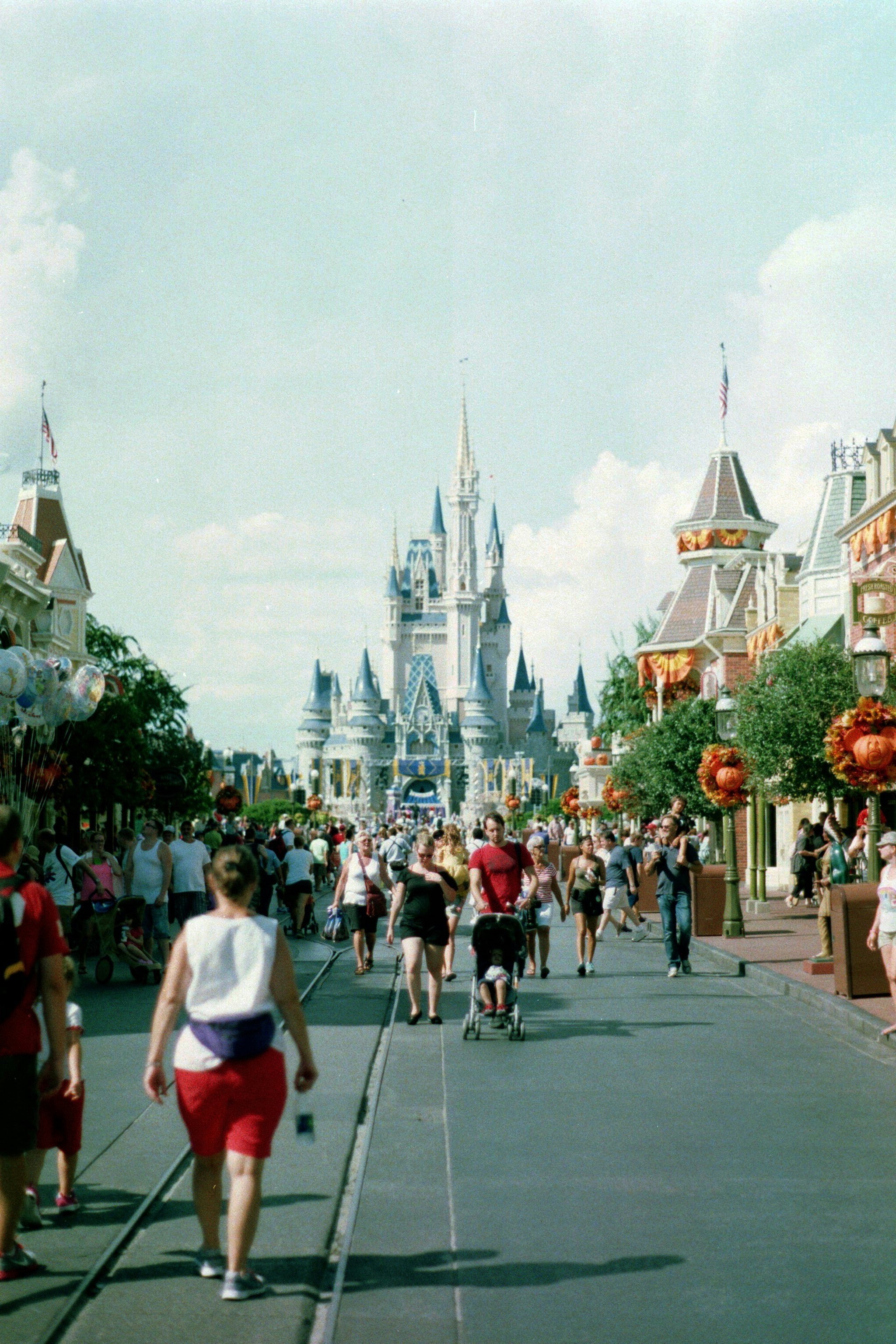 A group of people walking down a street in front of a castle