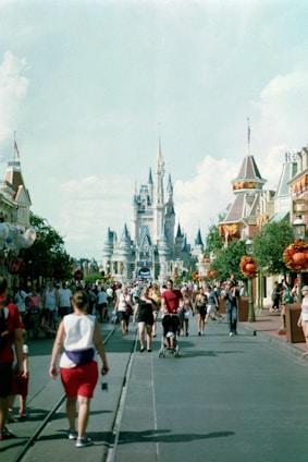 A group of people walking down a street in front of a castle