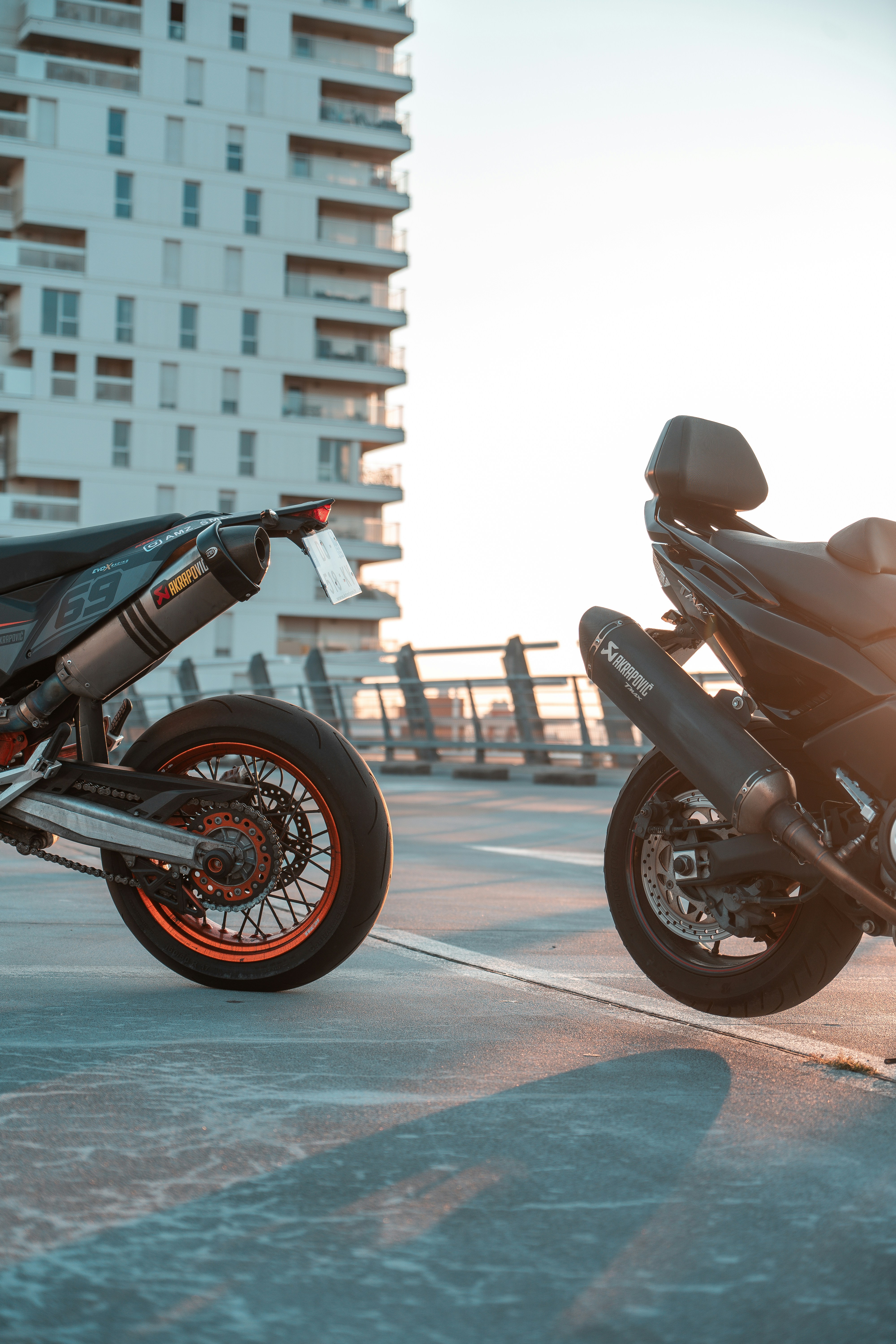 Two motorcycles parked next to each other in a parking lot