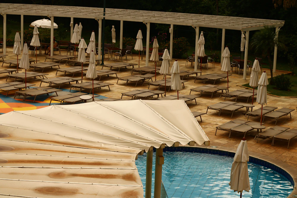 A resort pool with sun loungers and umbrellas
