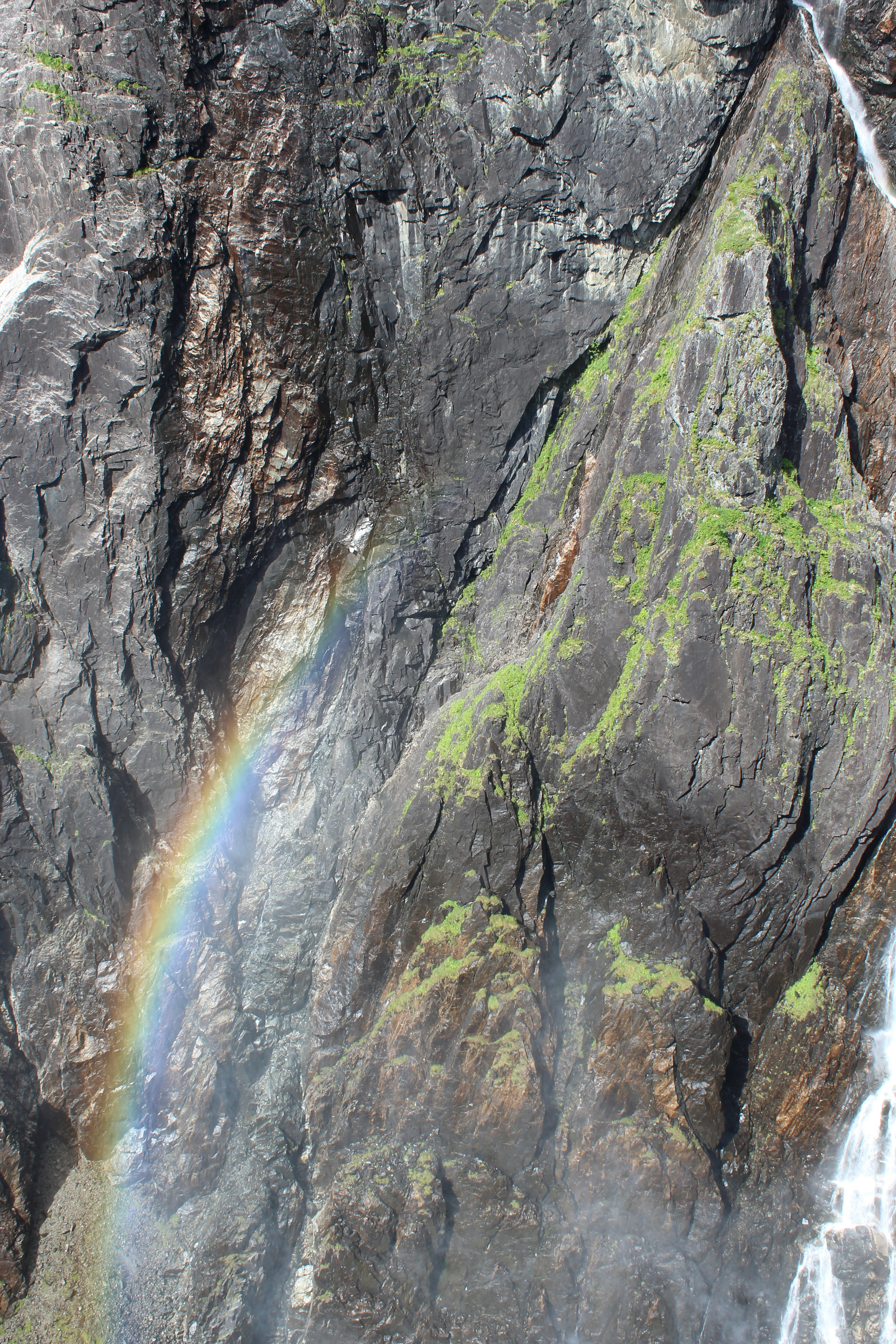 A waterfall with a rainbow in the middle of it
