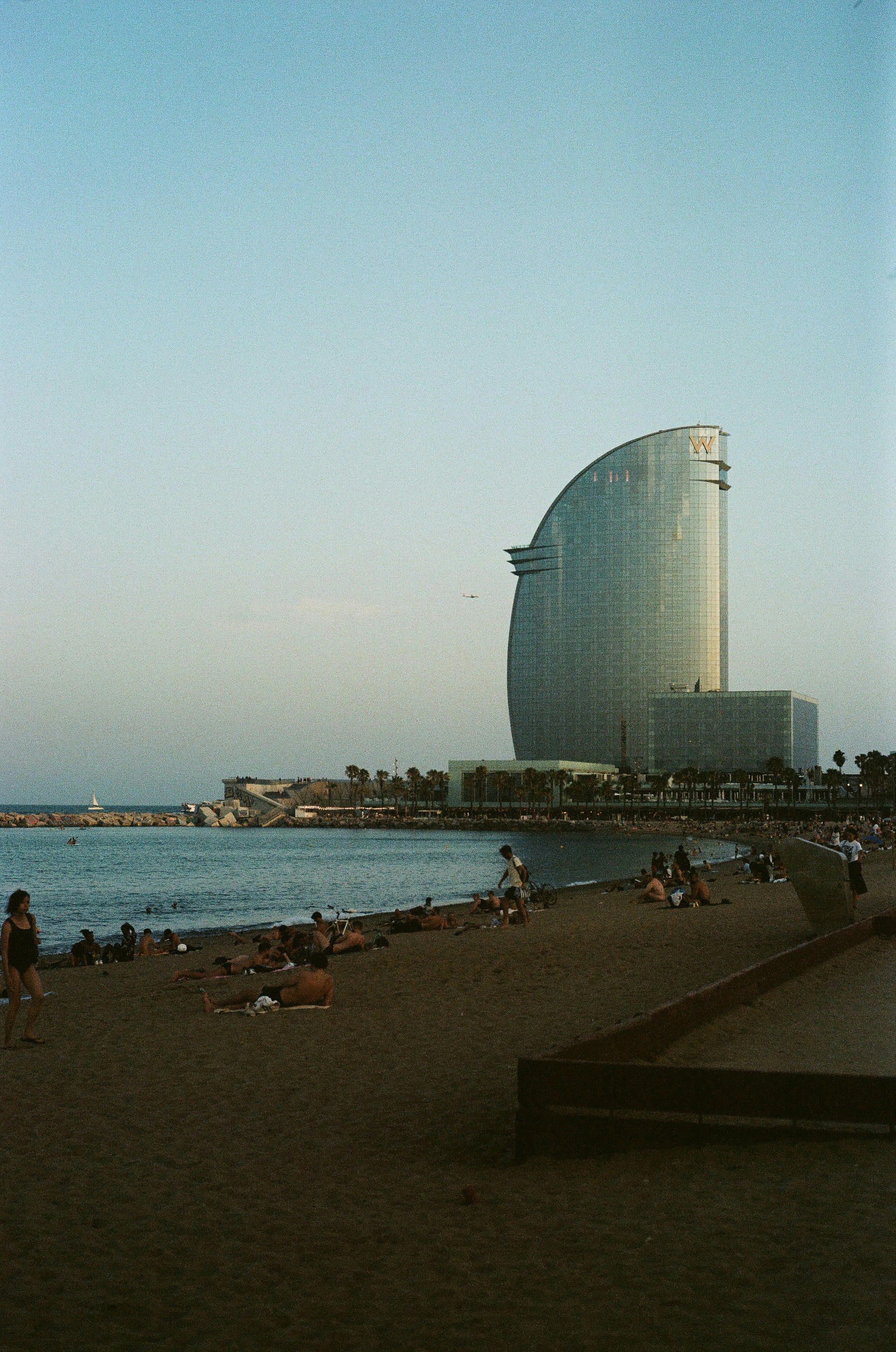 A group of people sitting on a beach next to a body of water