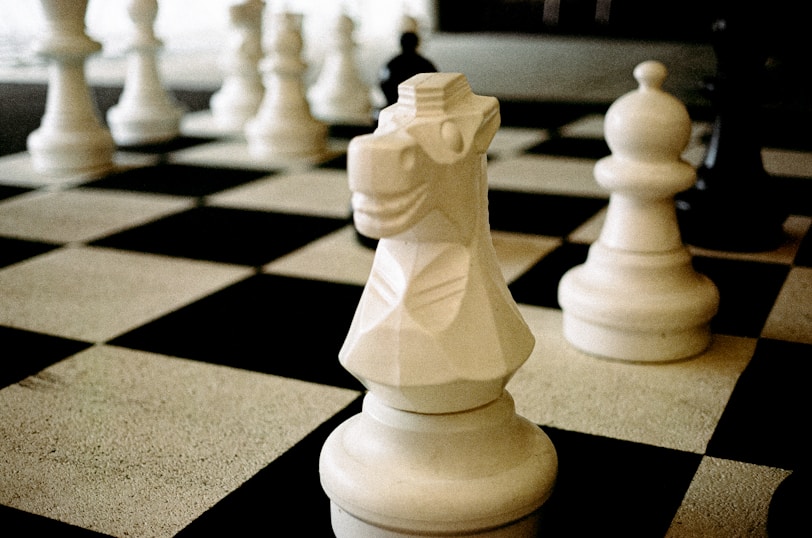 A black and white chess board with white pieces