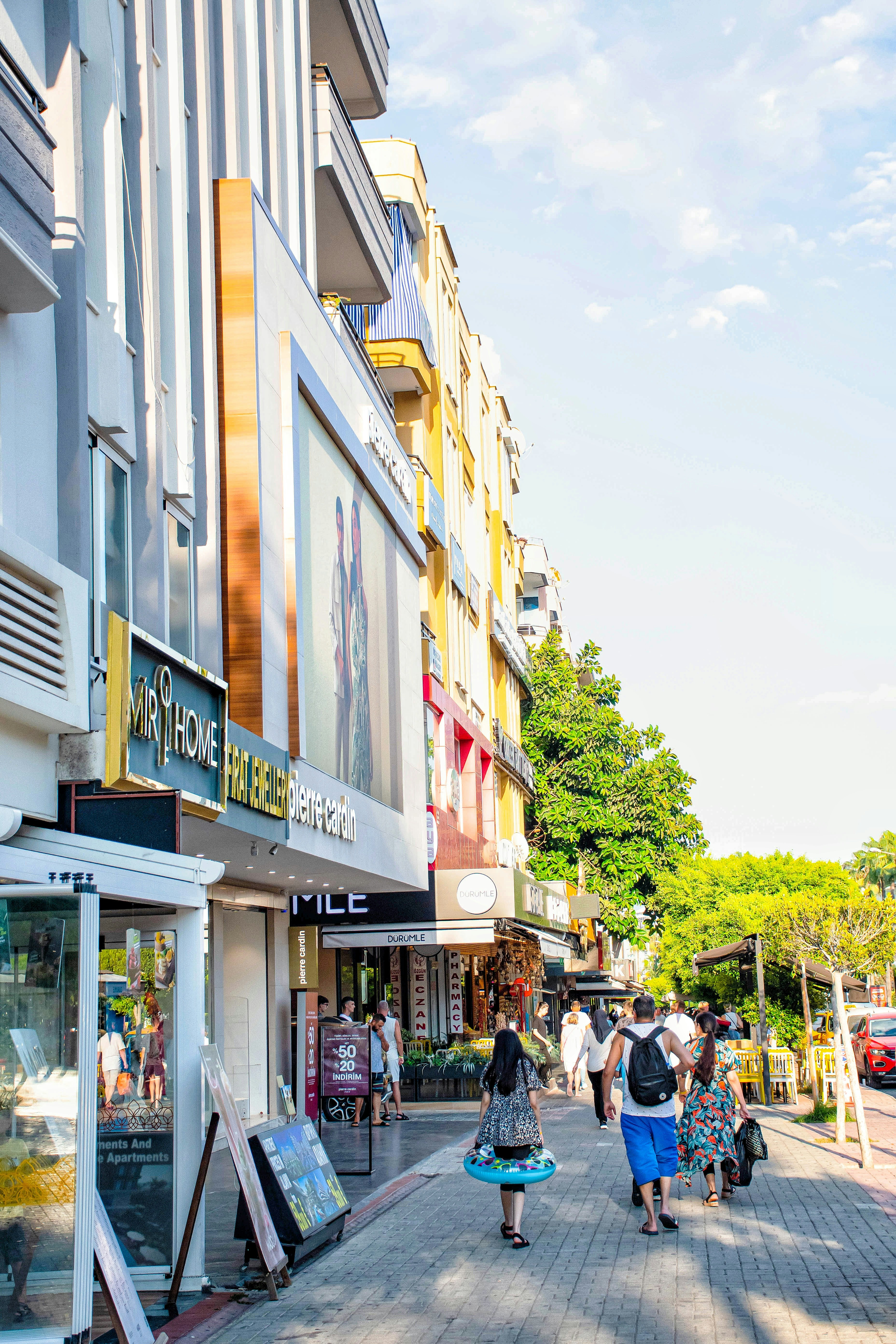 Eine Gruppe von Menschen geht eine Straße neben hohen Gebäuden entlang