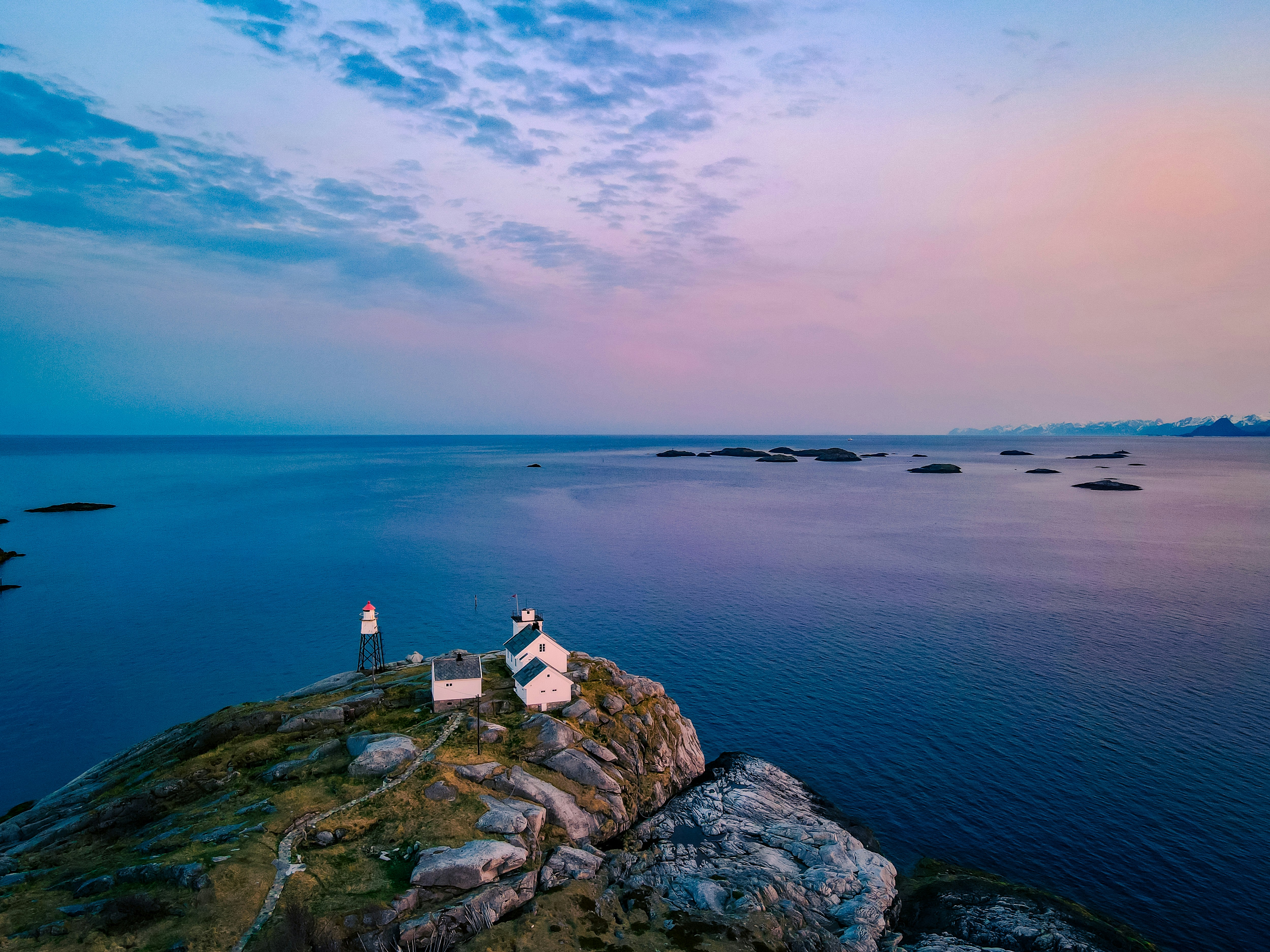 Ein paar kleine weiße Gebäude, die auf einem Felsen thronen