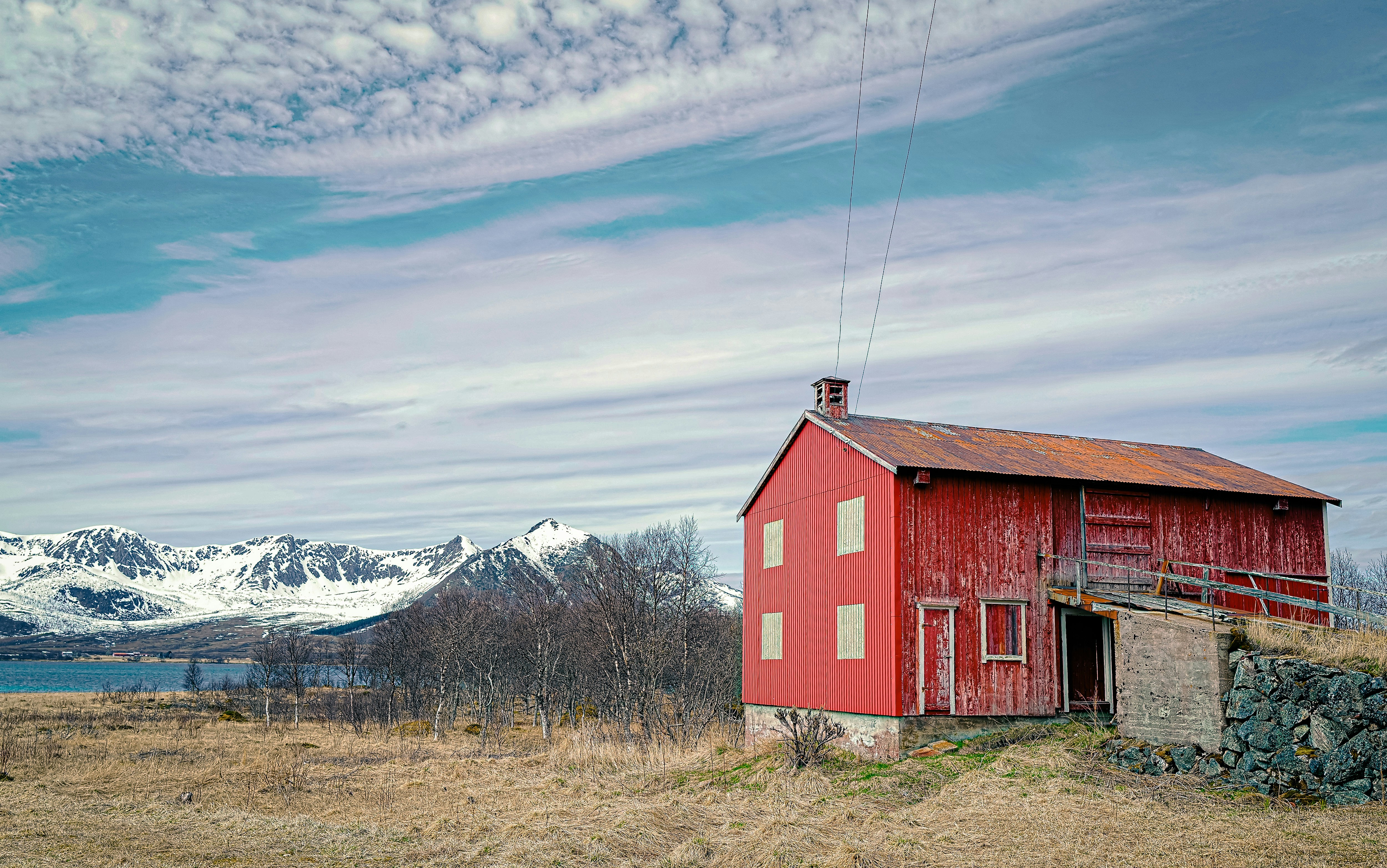 Ein rotes Haus, das auf einem trockenen Grasfeld sitzt