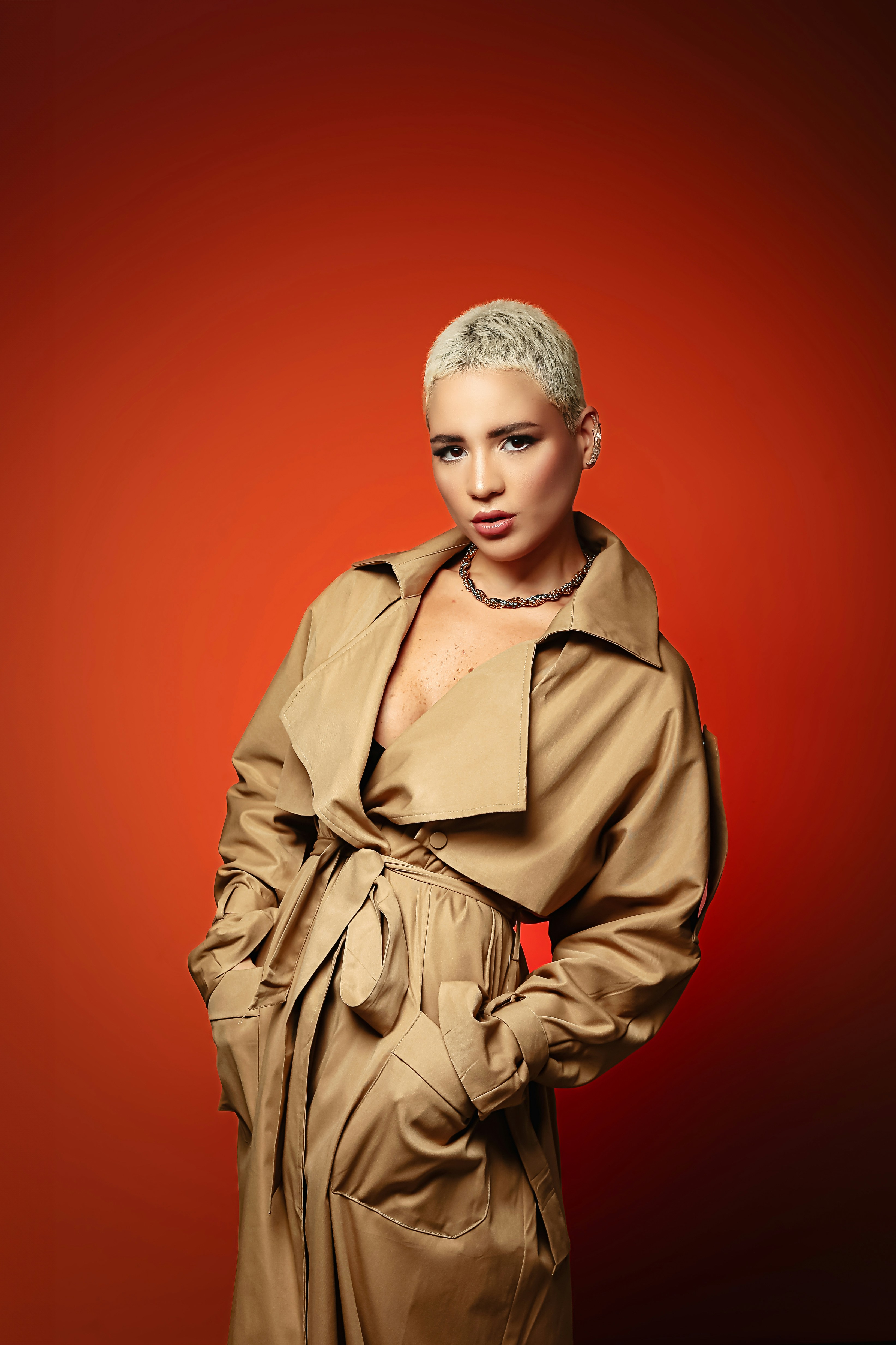 A woman in a trench coat posing for a picture