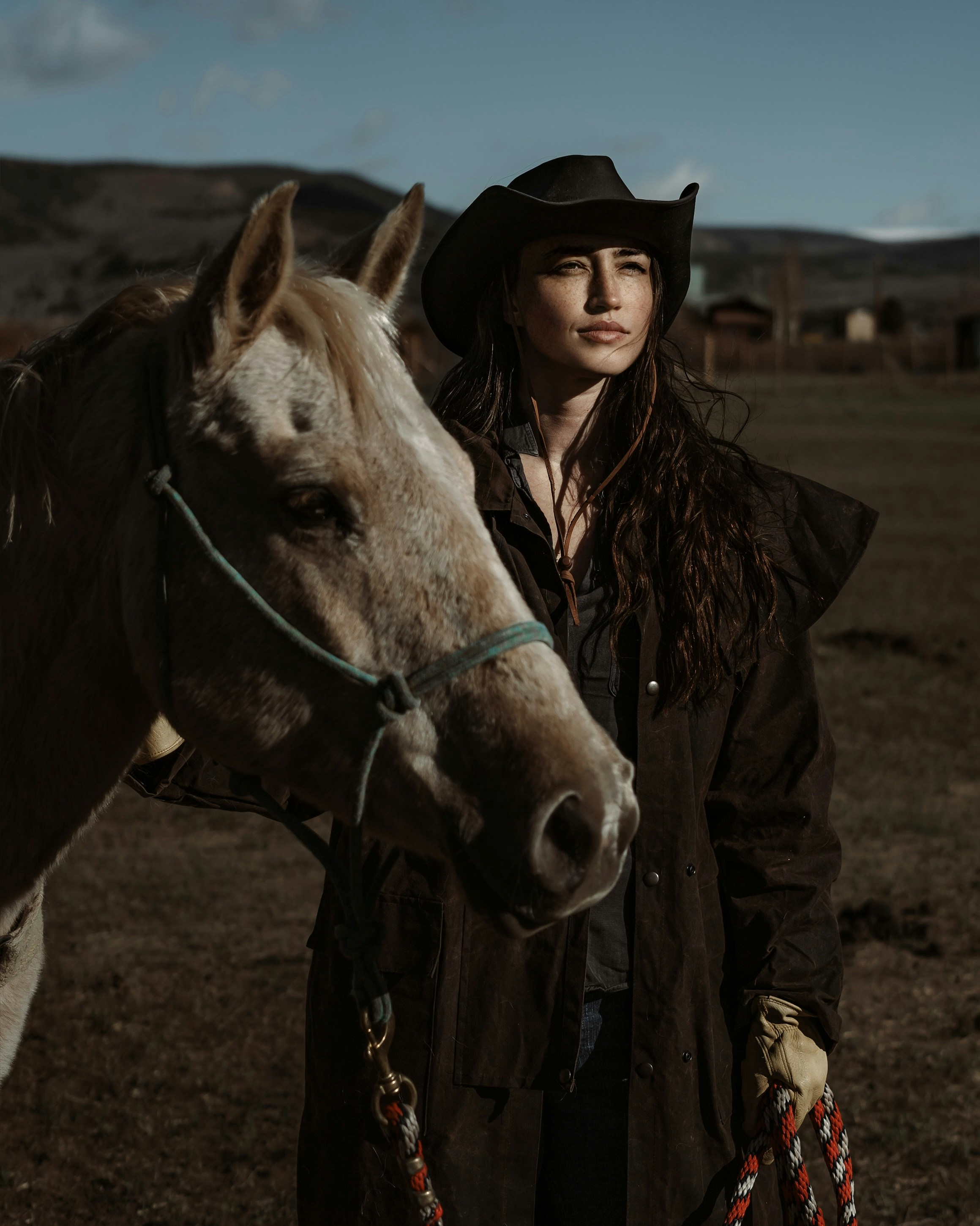 A woman standing next to a horse in a field