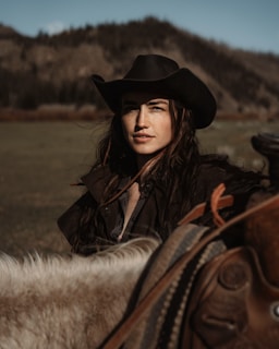 A woman in a cowboy hat riding a horse