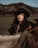 A woman in a cowboy hat riding a horse