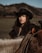 A woman in a cowboy hat riding a horse
