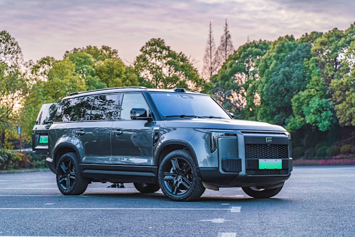 A grey land rover is parked in a parking lot