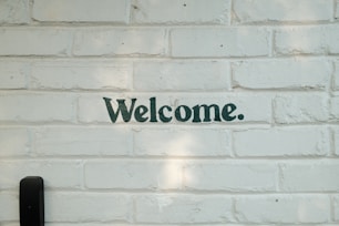A brick wall with a welcome sign on it