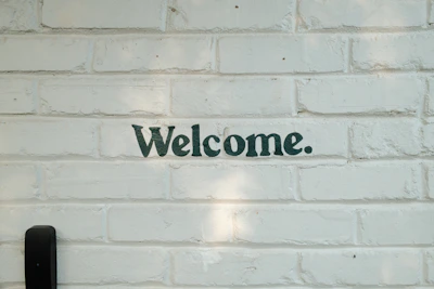 A brick wall with a welcome sign on it