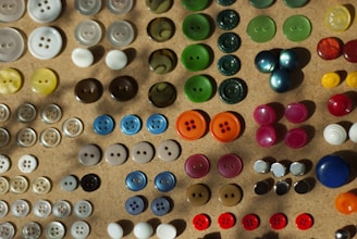 A bunch of different colored buttons on a table