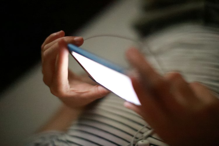 Person holding a smartphone and checking notifications for a Cochrane trades business