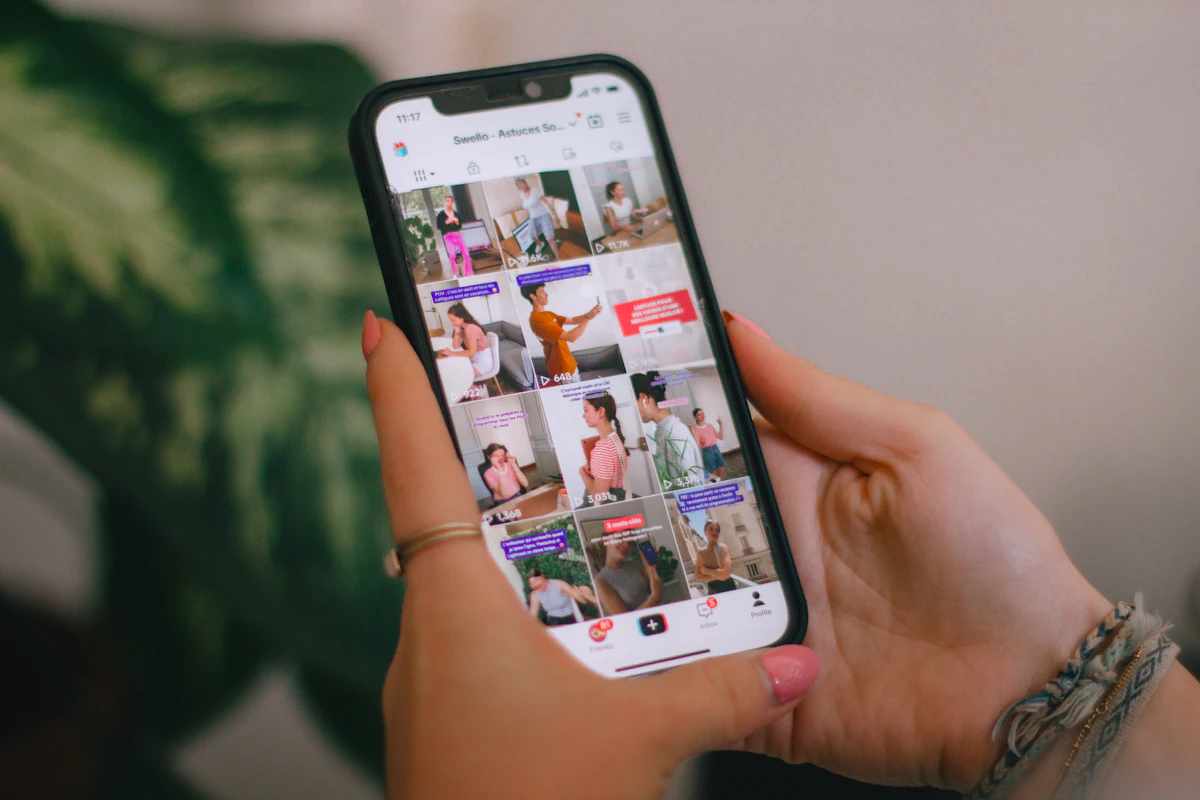 Mano sujetando un móvil con la parrilla de Instagram abierta, con luz natural