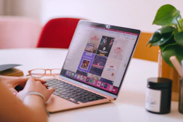 A woman sitting at a table using a laptop computer