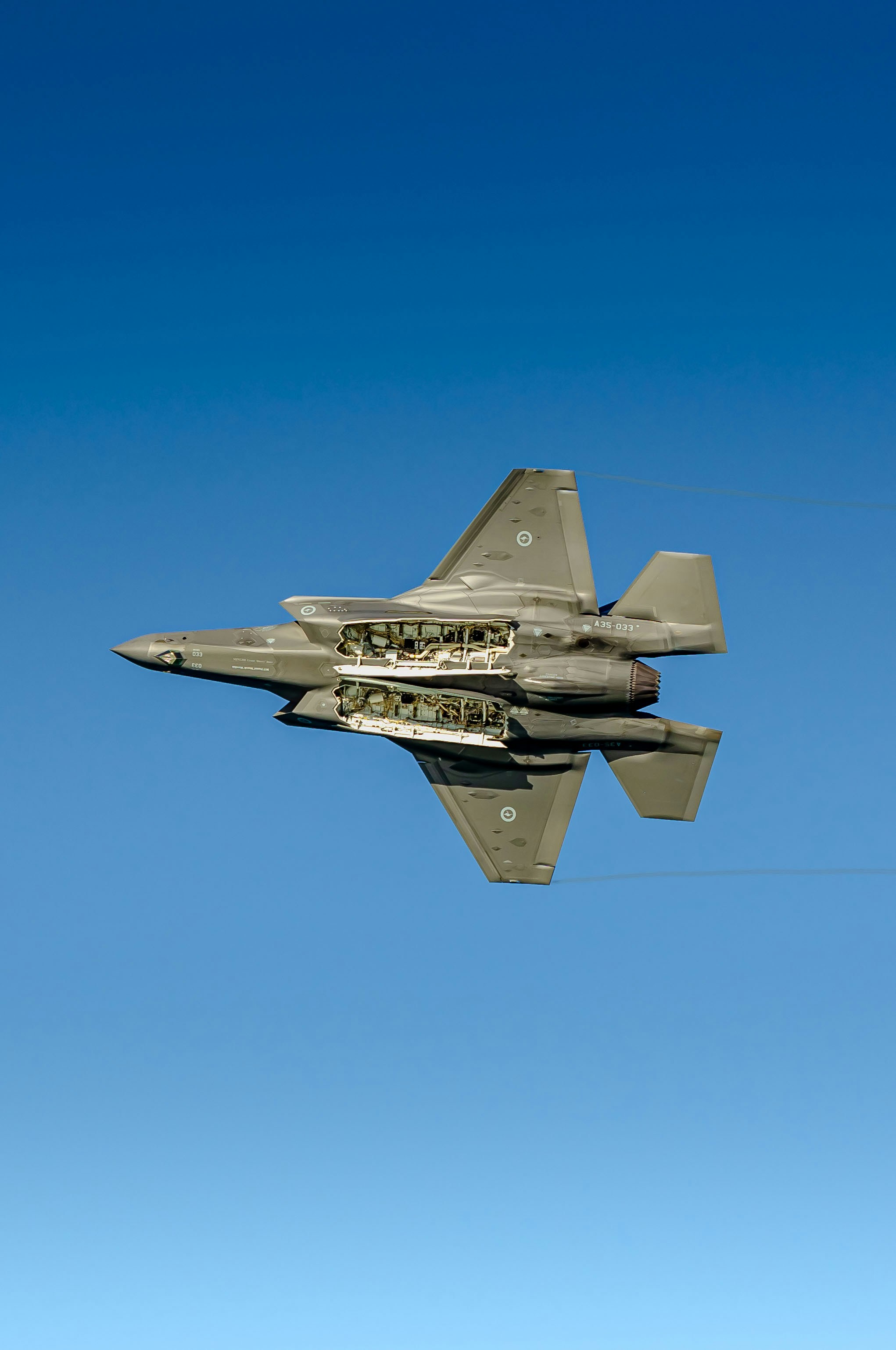 A fighter jet flying through a blue sky