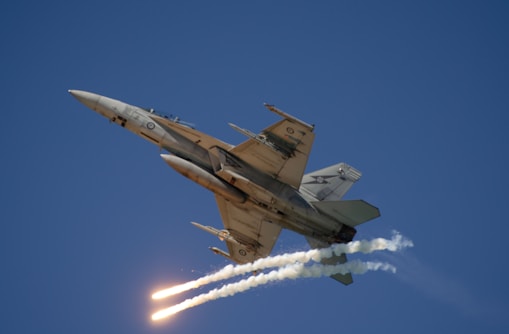 A fighter jet flying through a blue sky