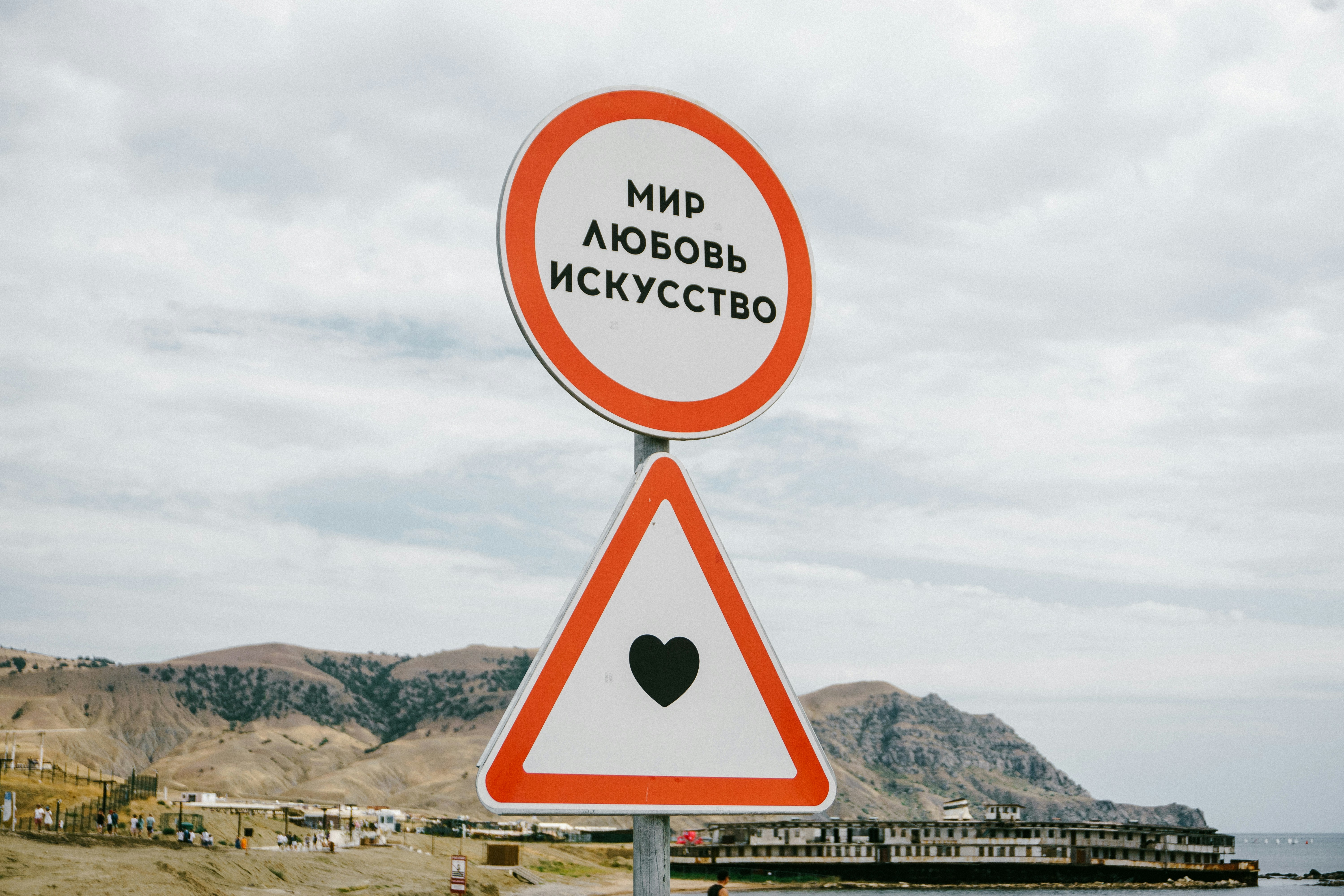 A red and white sign sitting on the side of a road