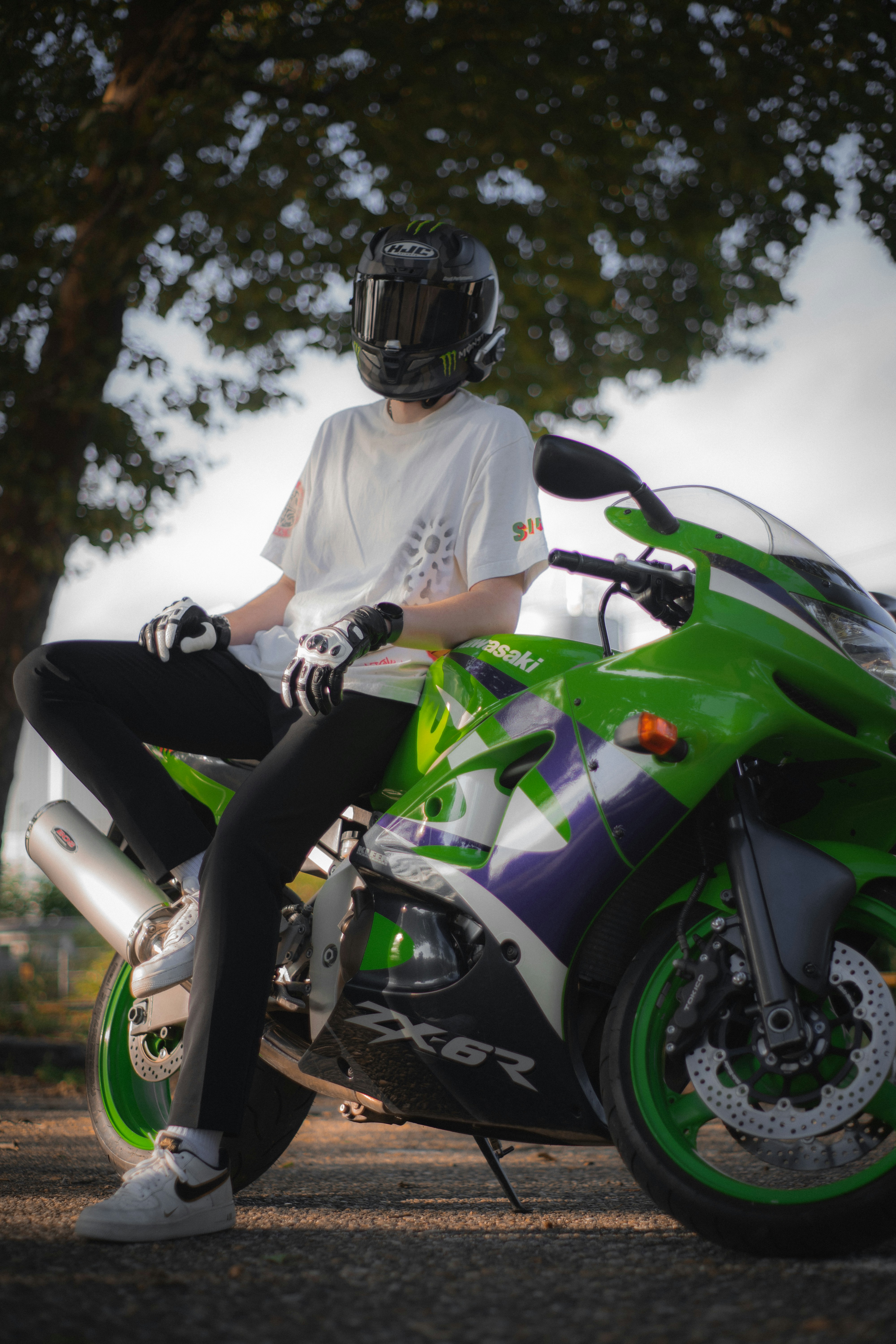 A man sitting on top of a green motorcycle