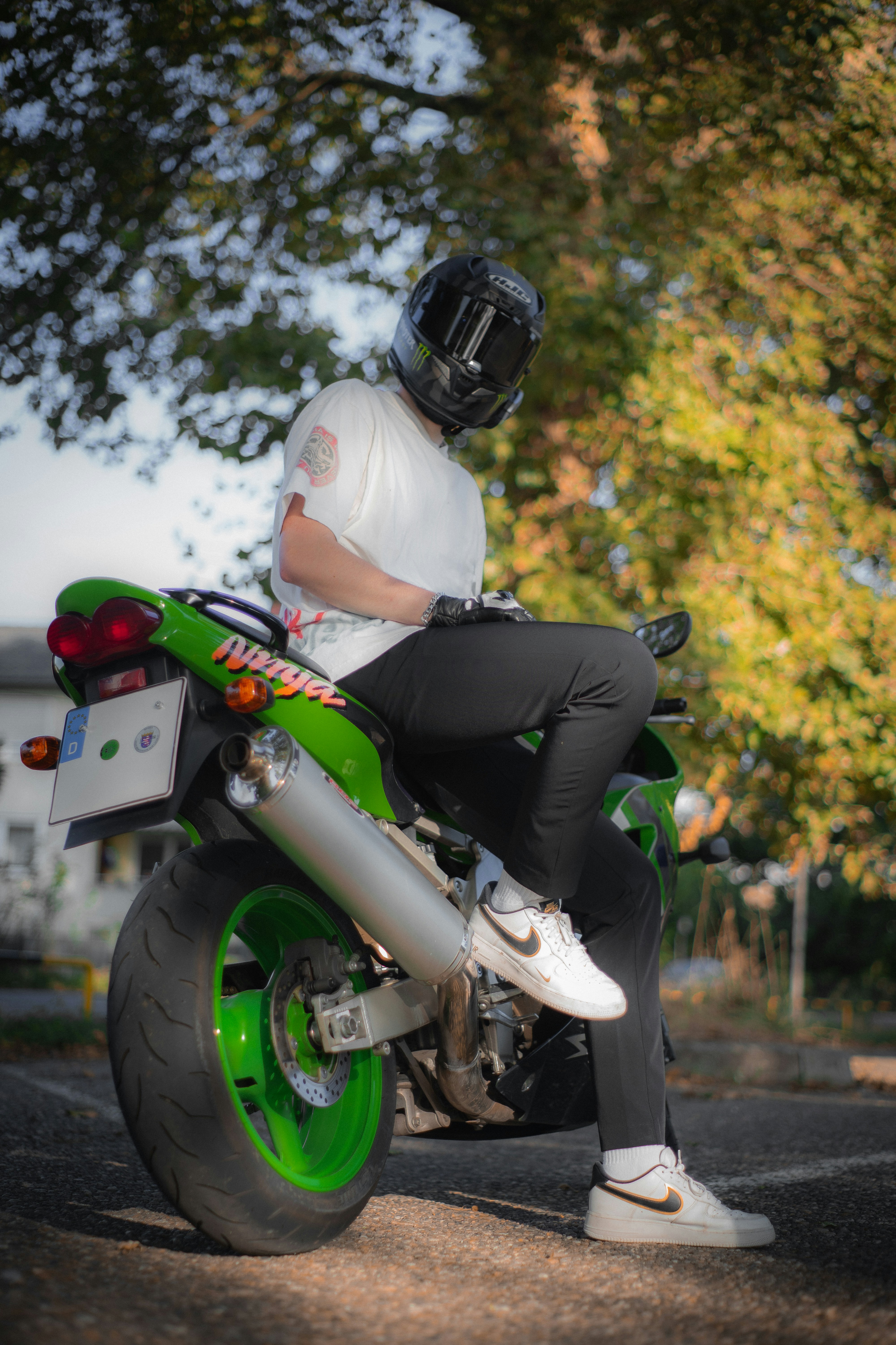 A man riding on the back of a green motorcycle