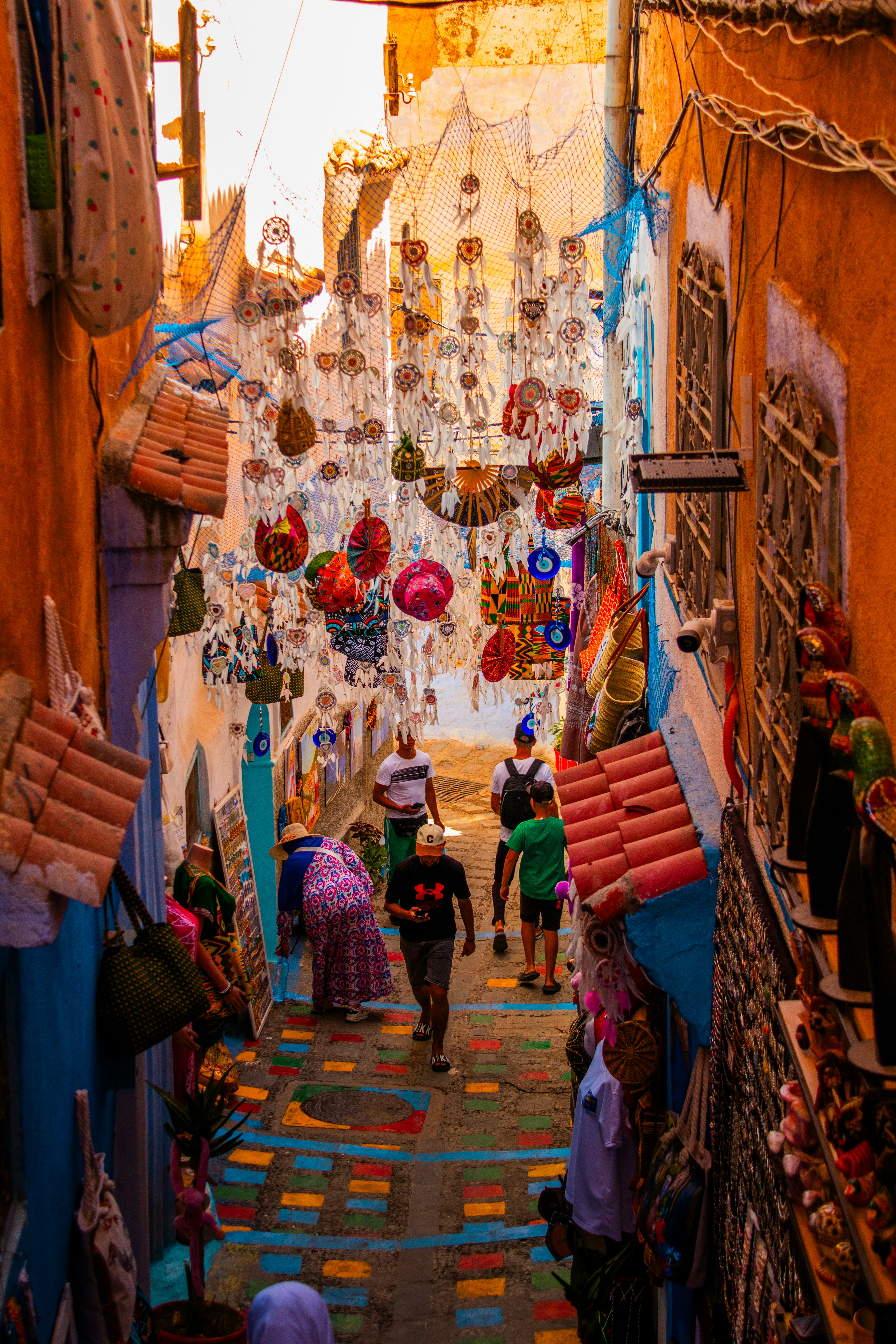 A narrow alley way with people walking down it