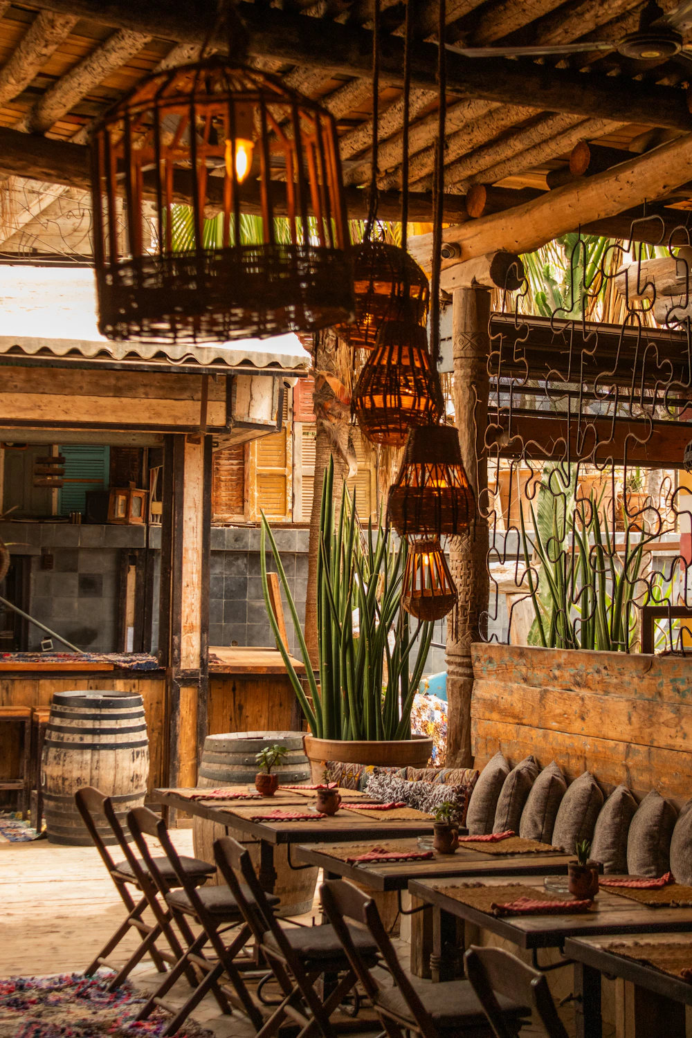 Restaurante con mesas de madera, plantas y lámparas colgantes