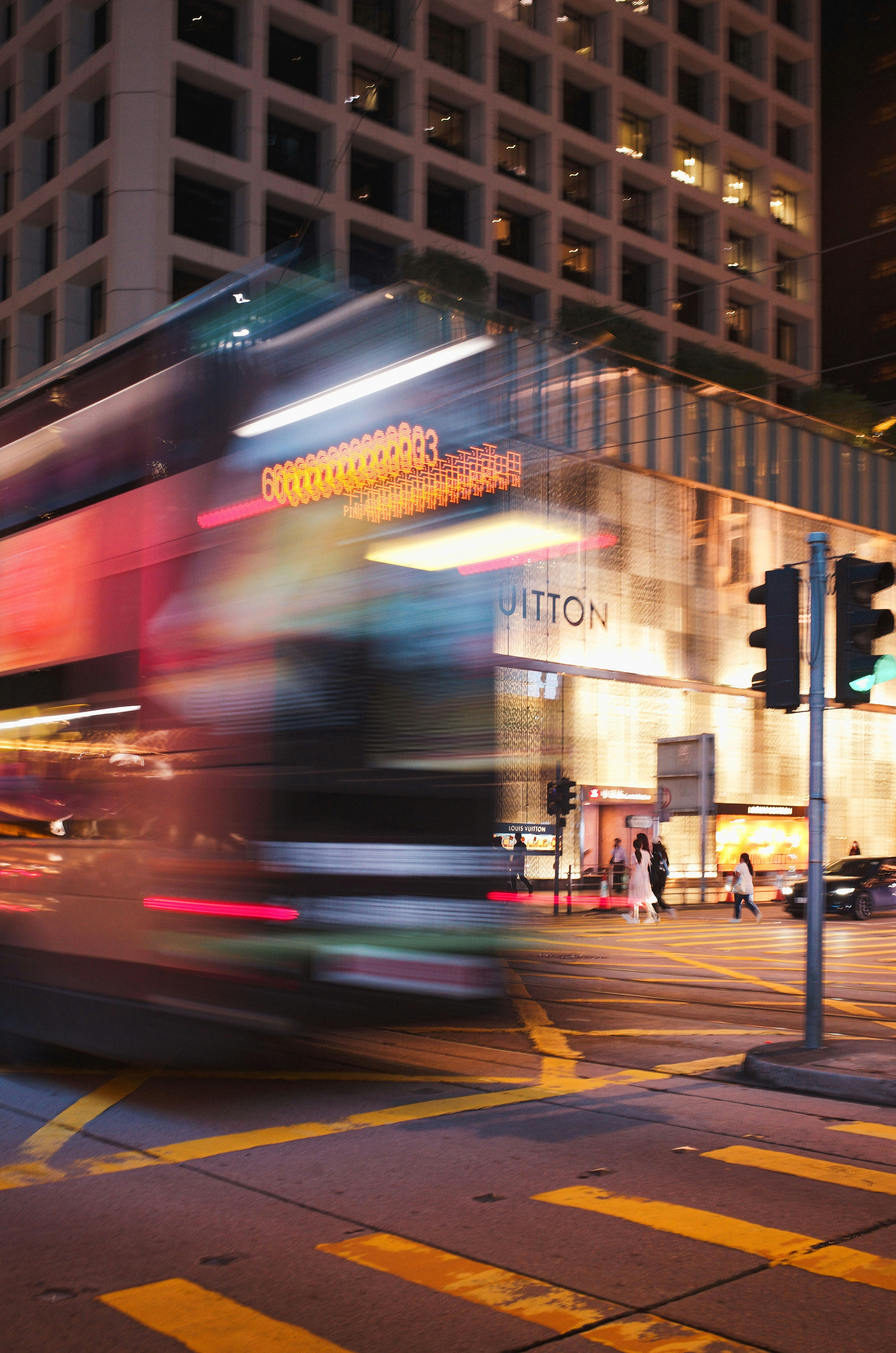 A double decker bus driving down a street at night