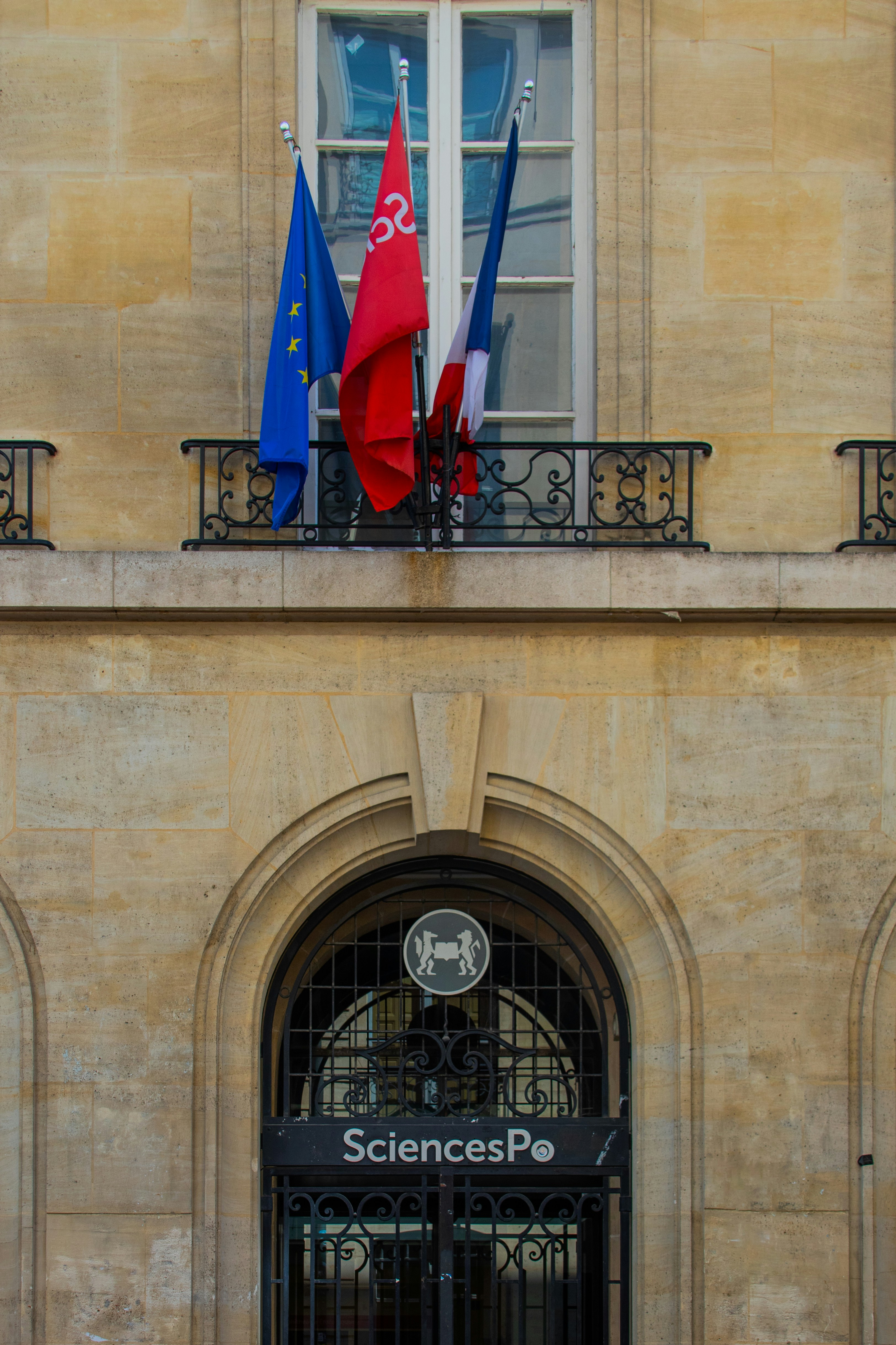 A building with a bunch of flags hanging from it's balconies