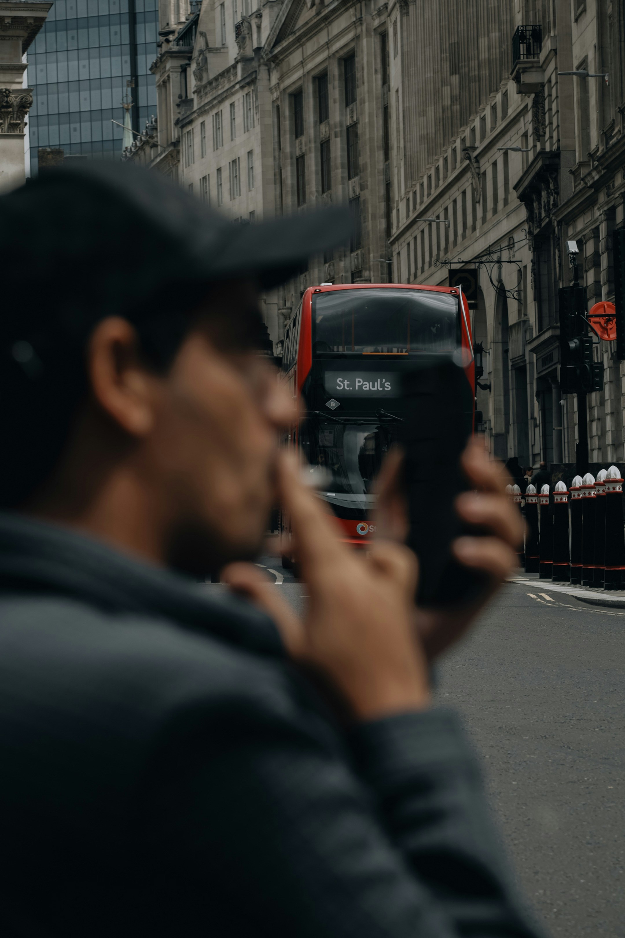 A man taking a picture of a double decker bus