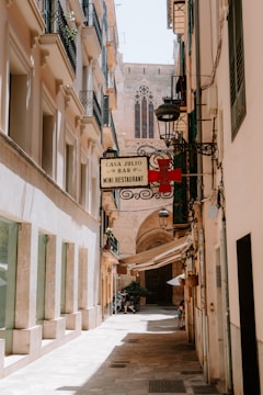 A narrow street with a sign on the side of it