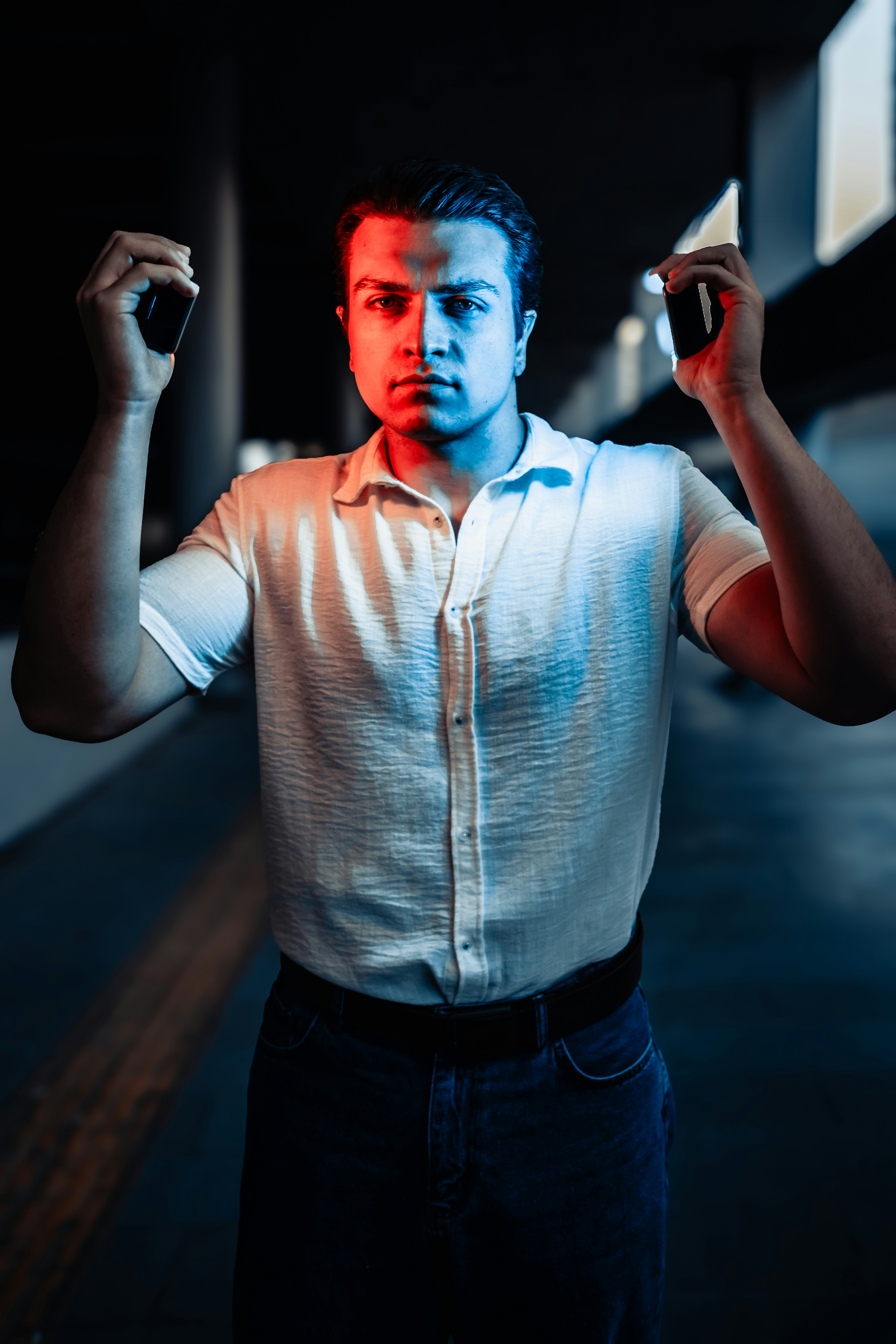 A man in a white shirt is holding a cell phone