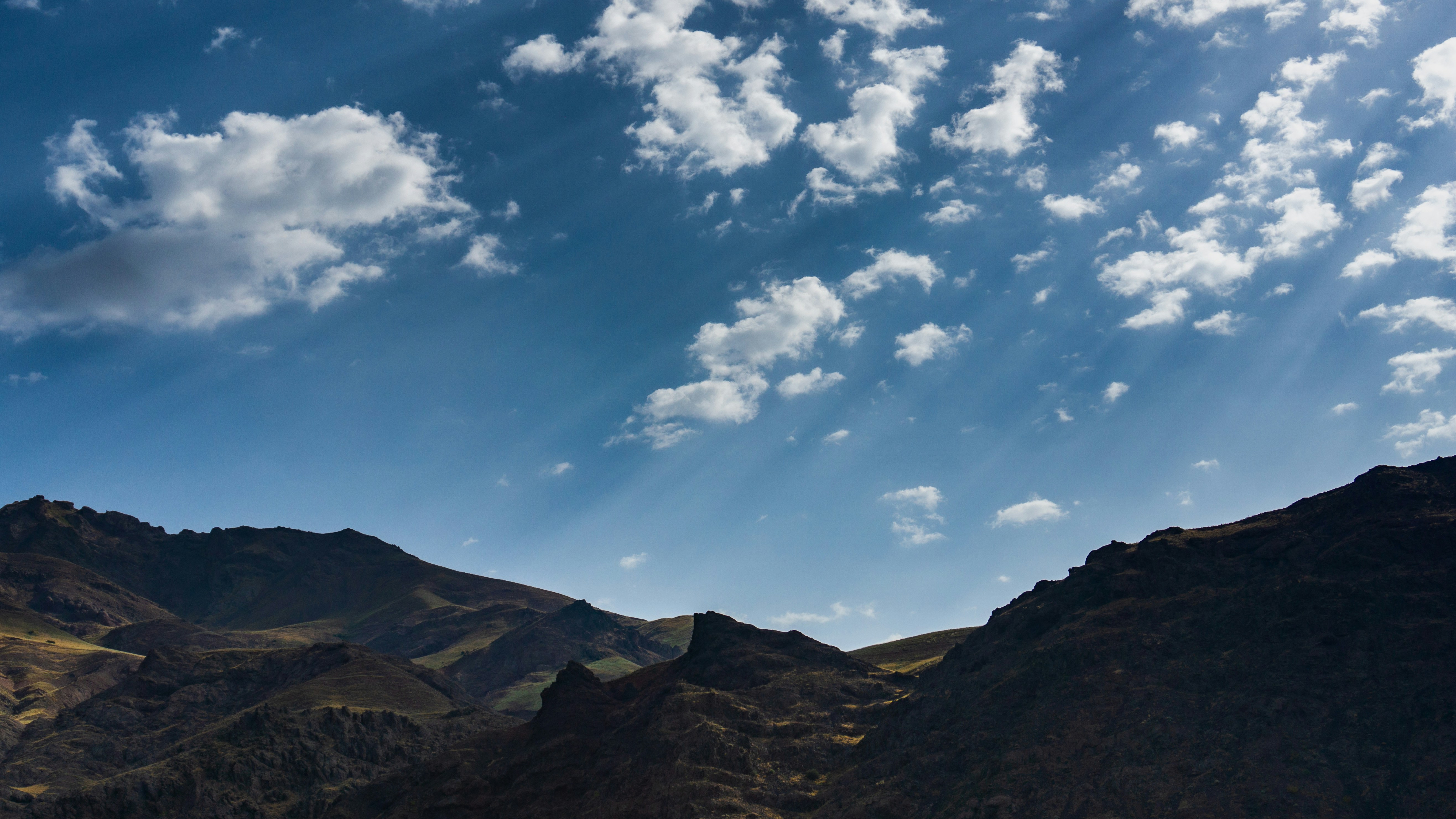 Una vista de una cadena montañosa con nubes en el cielo