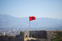 A red flag flying on top of a castle