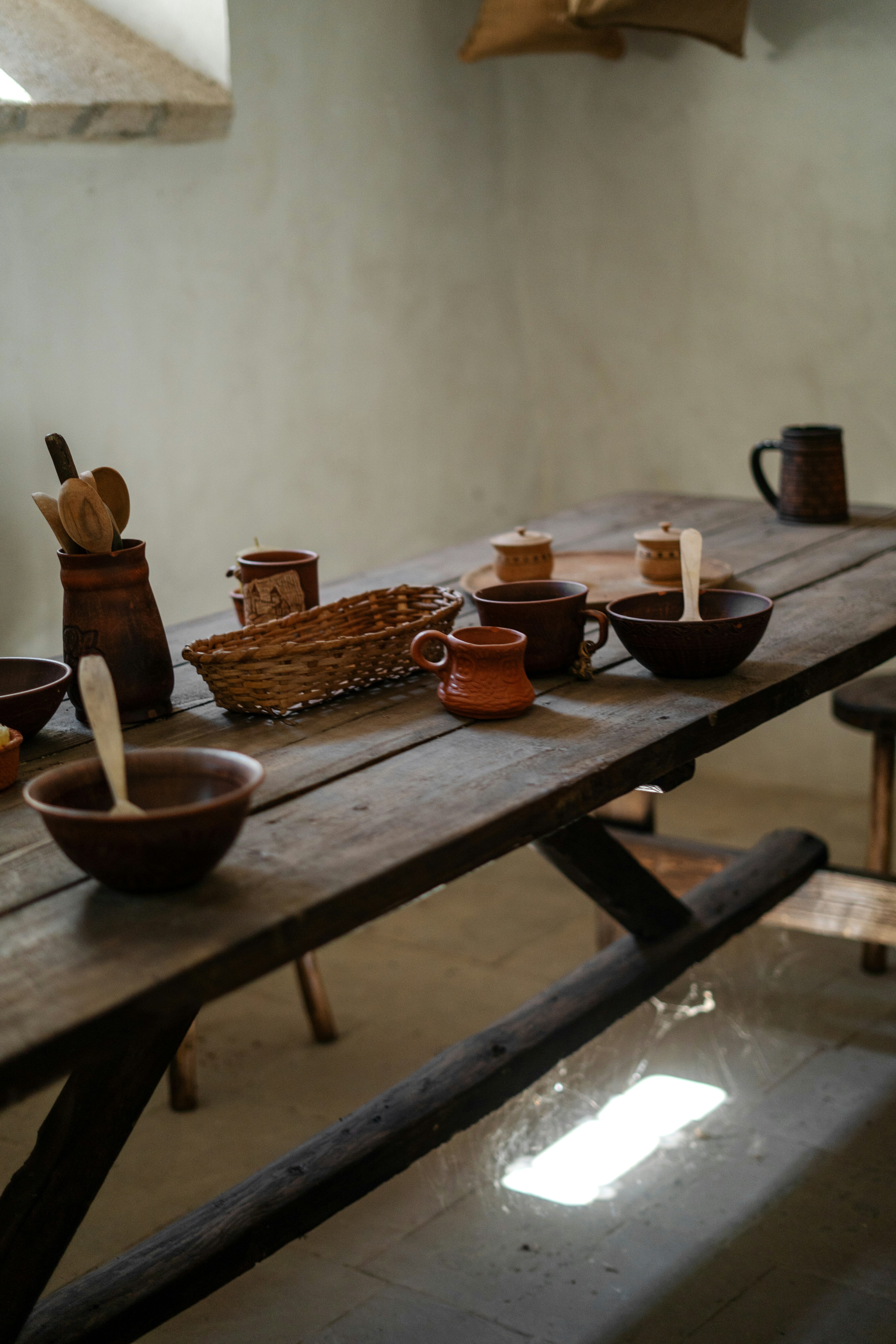 A wooden table topped with bowls and cups