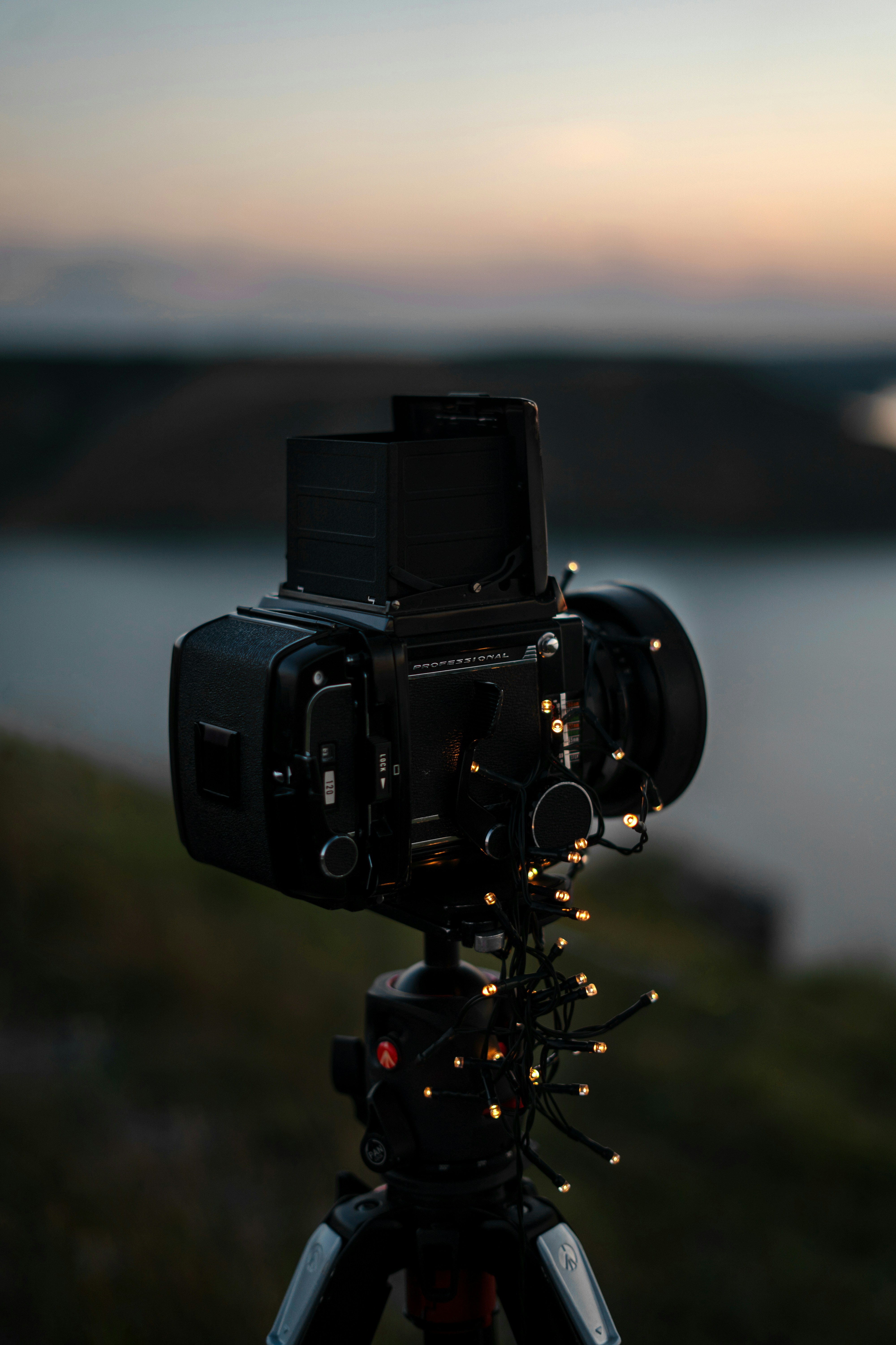 A camera on a tripod with a body of water in the background