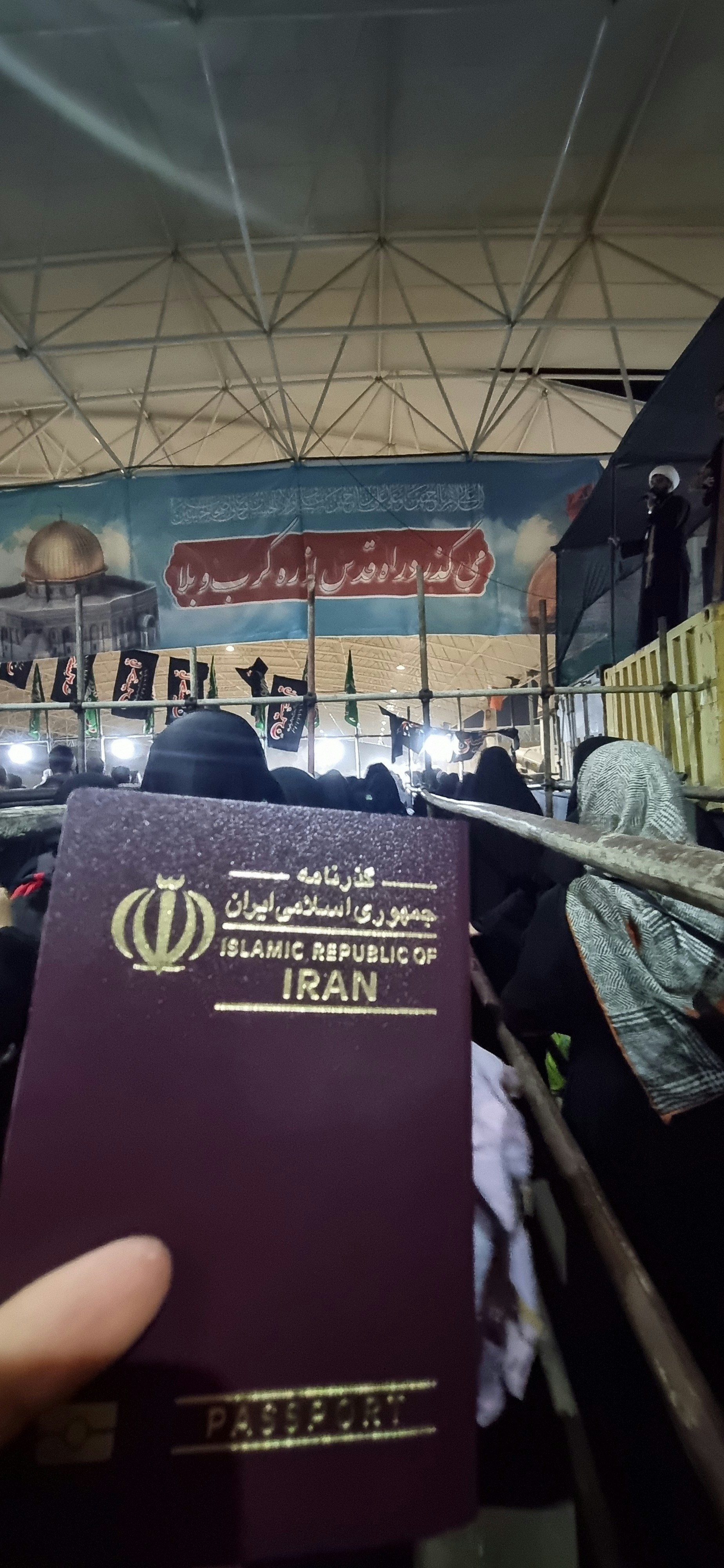 Une personne tenant un passeport devant une foule de personnes