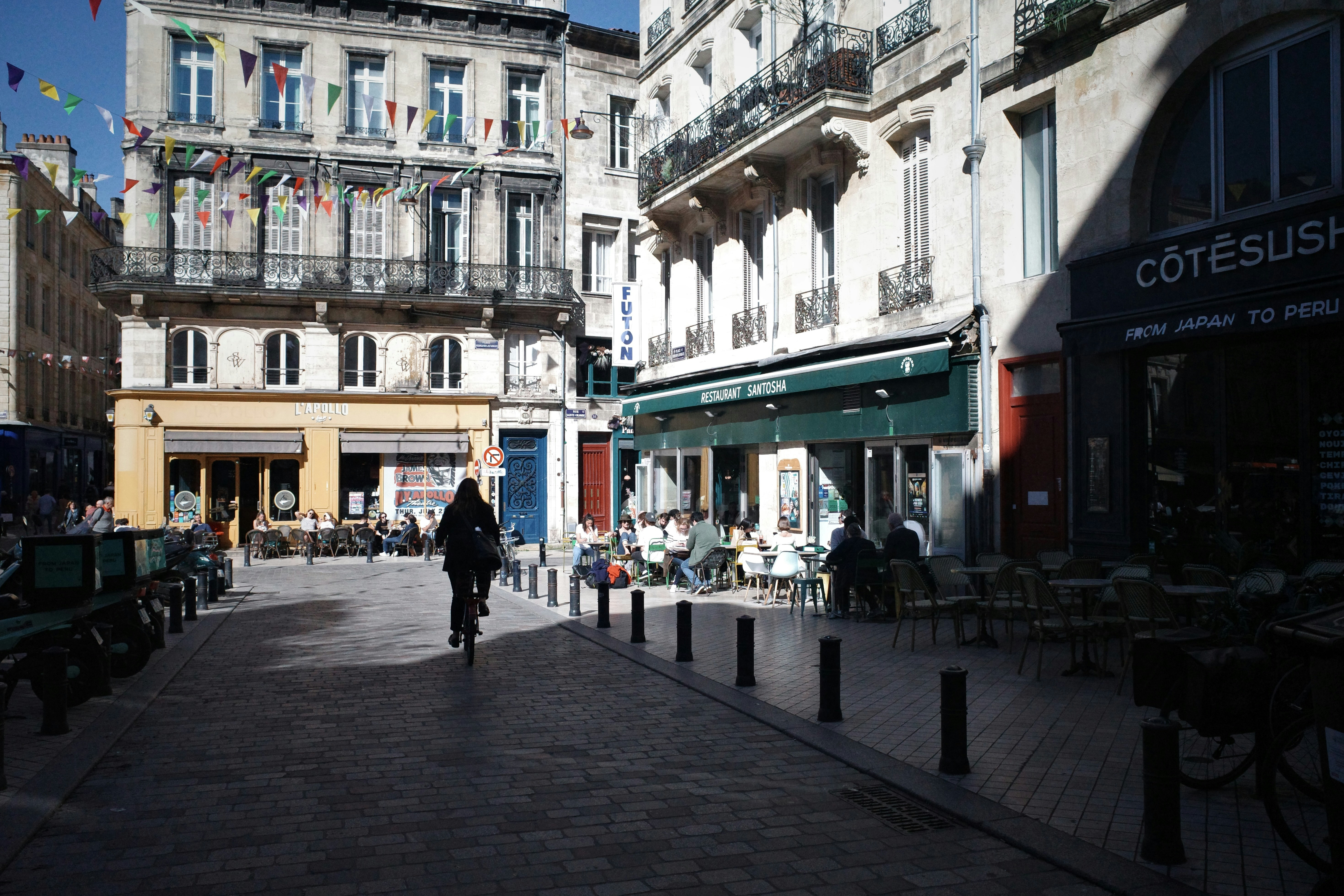 A man walking down a street next to tall buildings